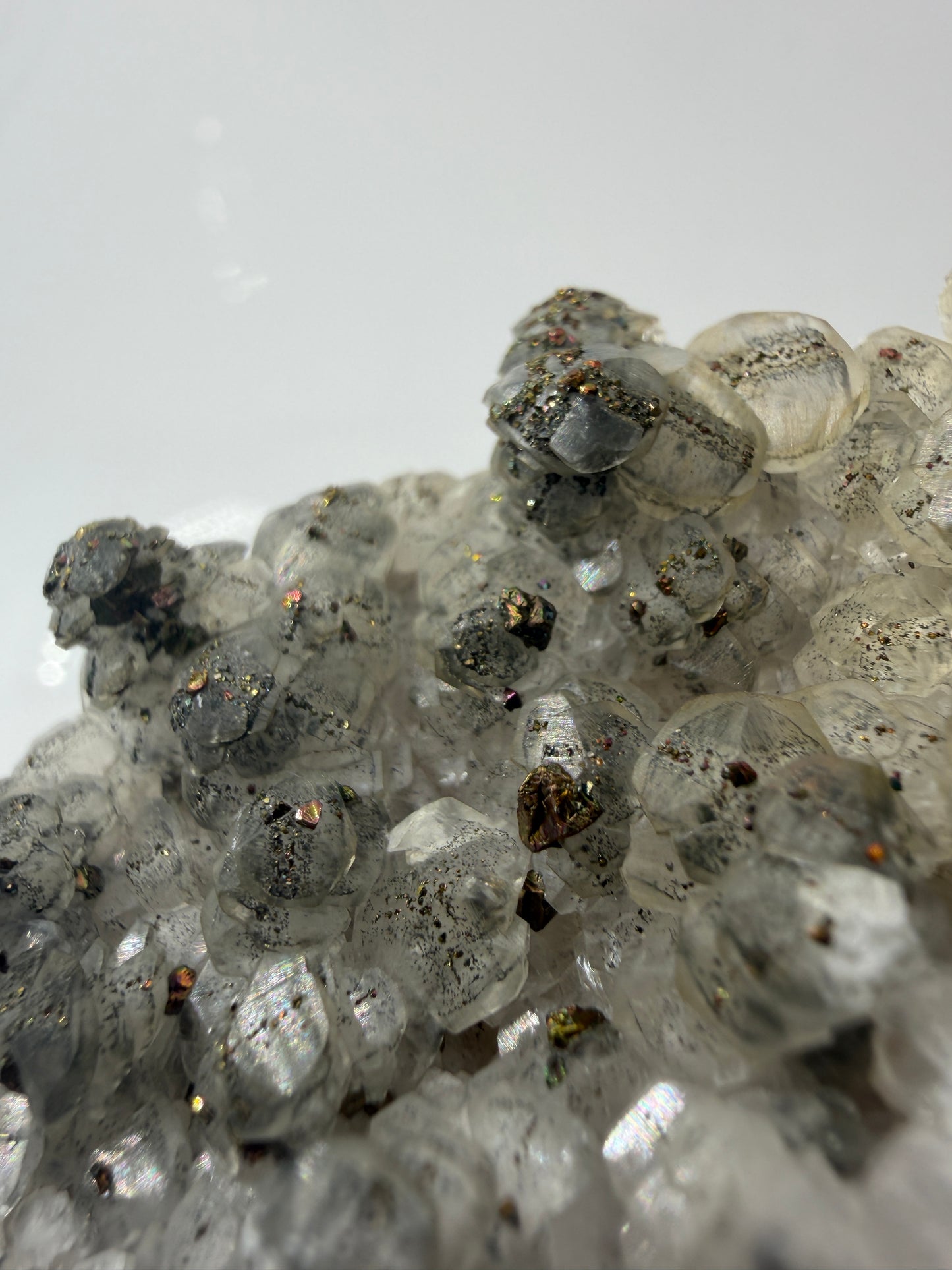Weißer Calcit mit goldglänzenden Pyrit-Kristallen auf Gesteinsmatrix aus Herdringen, Sauerland.