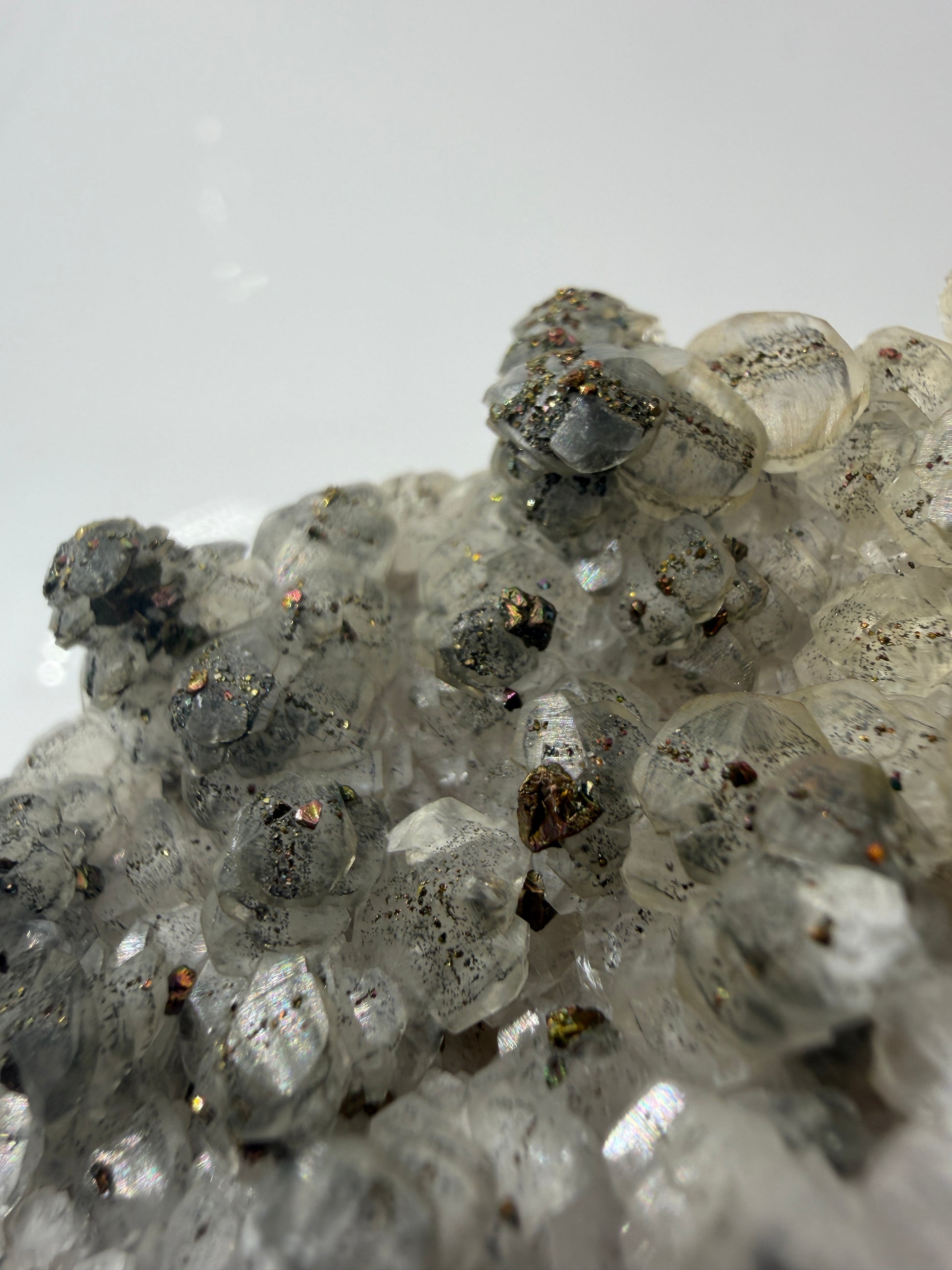 Weißer Calcit mit goldglänzenden Pyrit-Kristallen auf Gesteinsmatrix aus Herdringen, Sauerland.