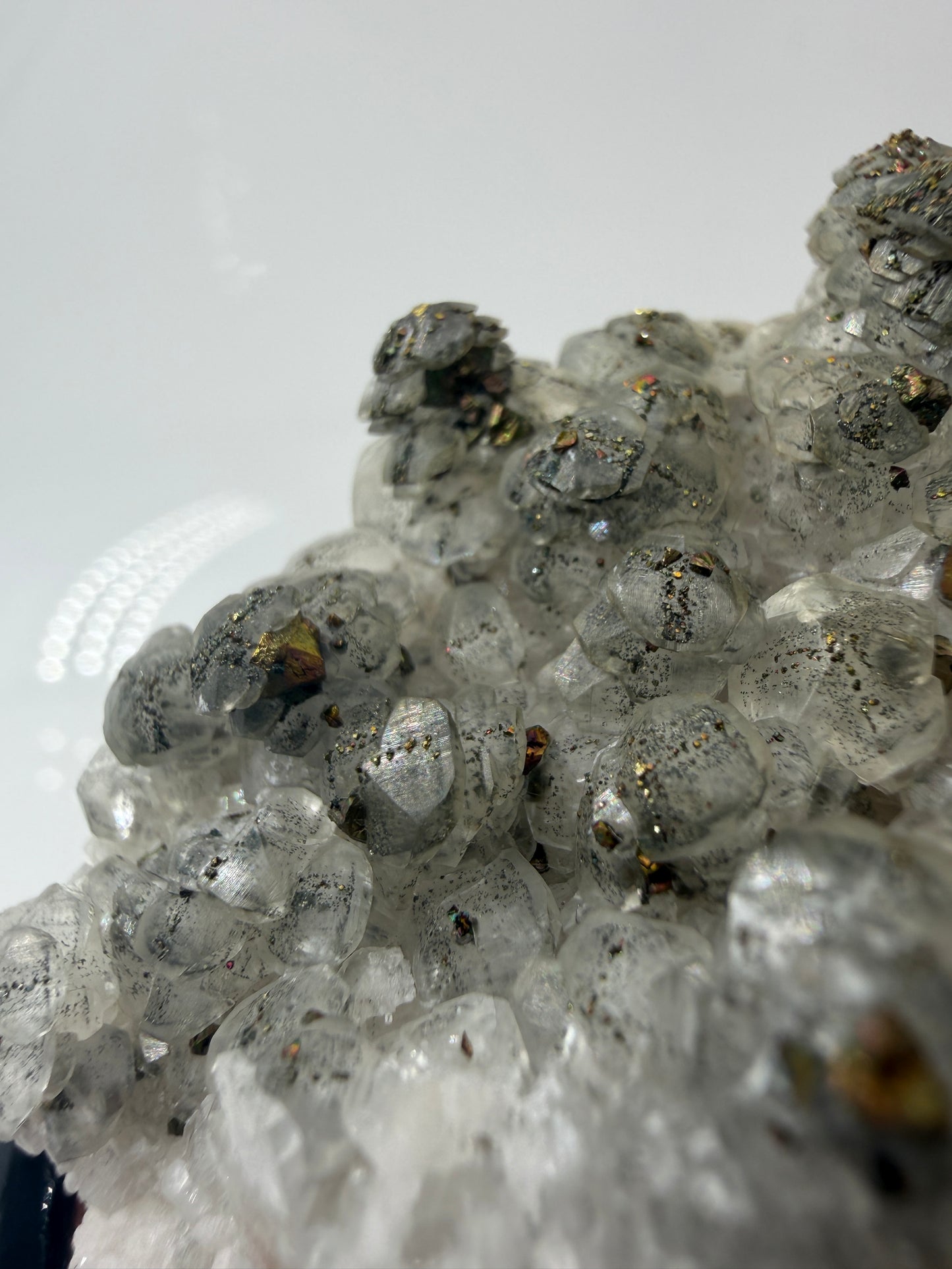 Weißer Calcit mit goldglänzenden Pyrit-Kristallen auf Gesteinsmatrix aus Herdringen, Sauerland.