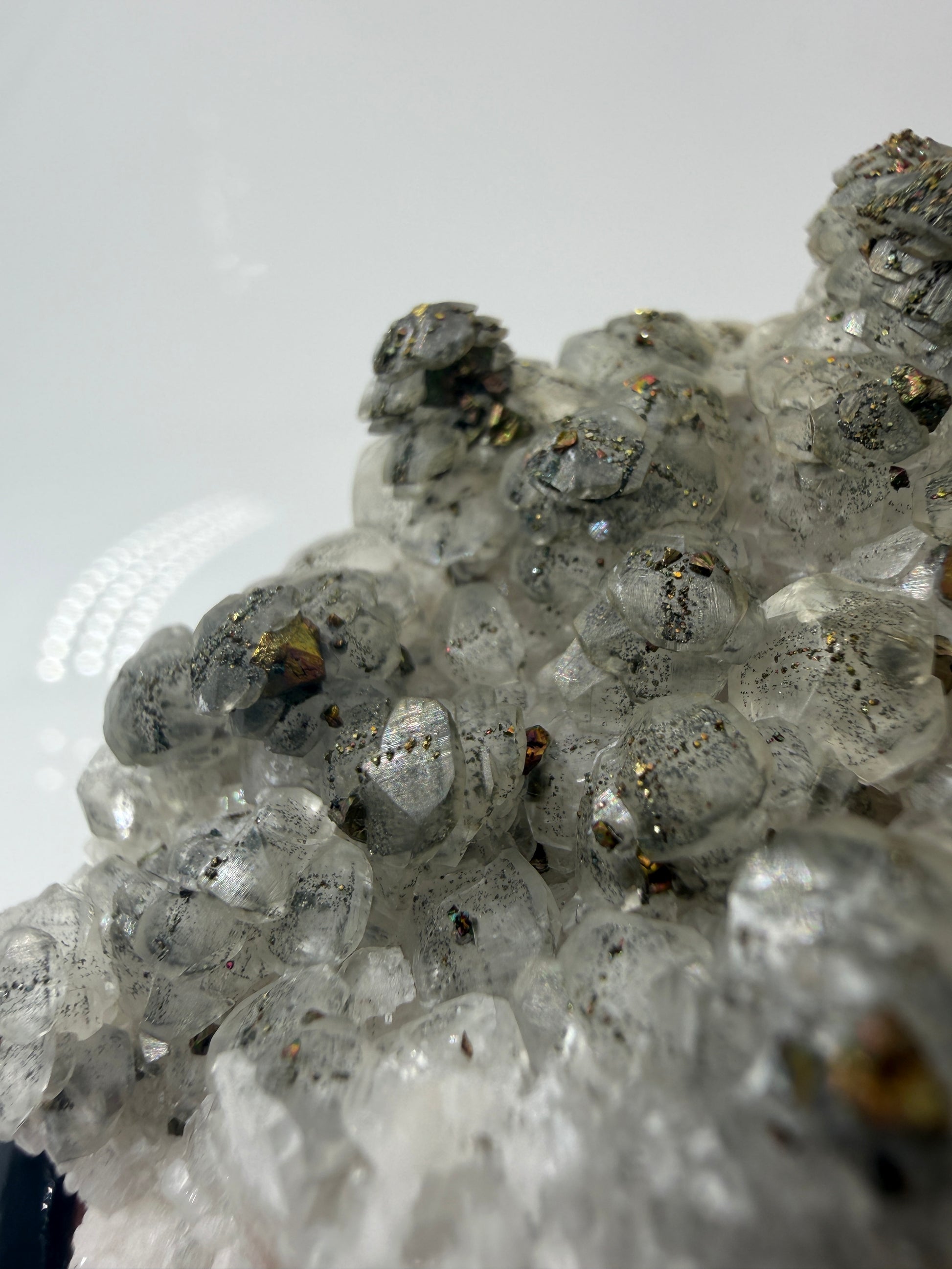 Weißer Calcit mit goldglänzenden Pyrit-Kristallen auf Gesteinsmatrix aus Herdringen, Sauerland.