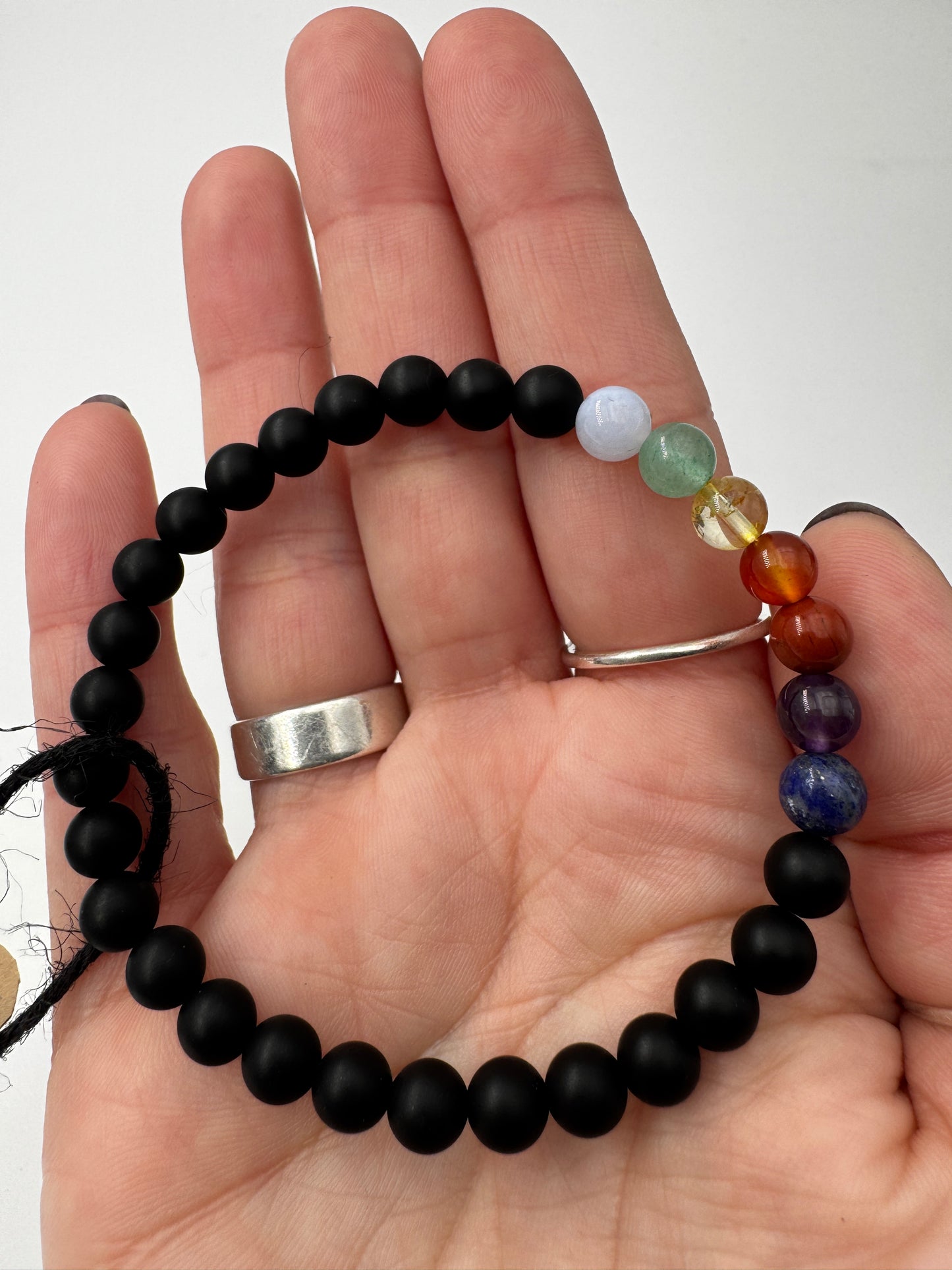 Armband aus mattem schwarzen Onyx mit sieben Chakra-Edelsteinkugeln in Lapislazuli, Amethyst, Jaspis, Karneol, Citrin, Aventurin und Aquamarin, 18 cm Umfang.
