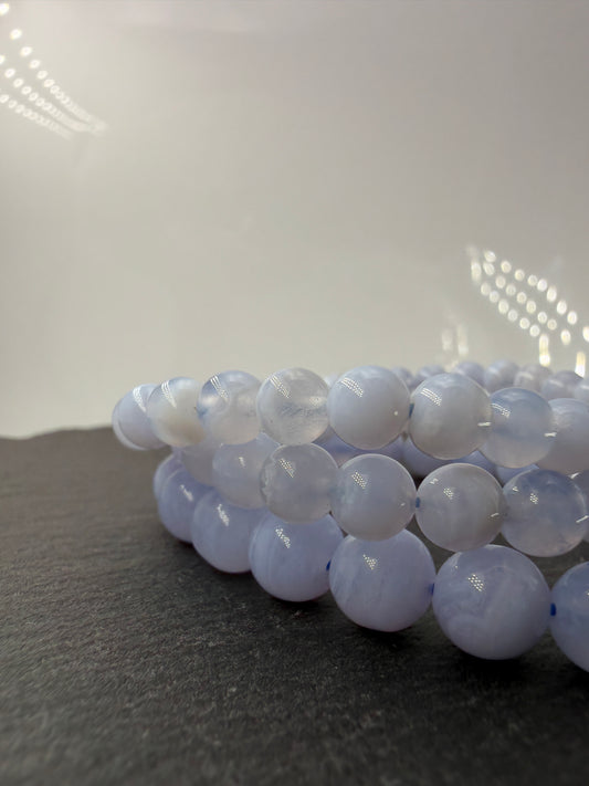 Ein zartblaues Kugelarmband aus poliertem Chalcedon, dessen gleichmäßige Perlen eine sanfte Lichtdurchlässigkeit und einen seidigen Glanz aufweisen.