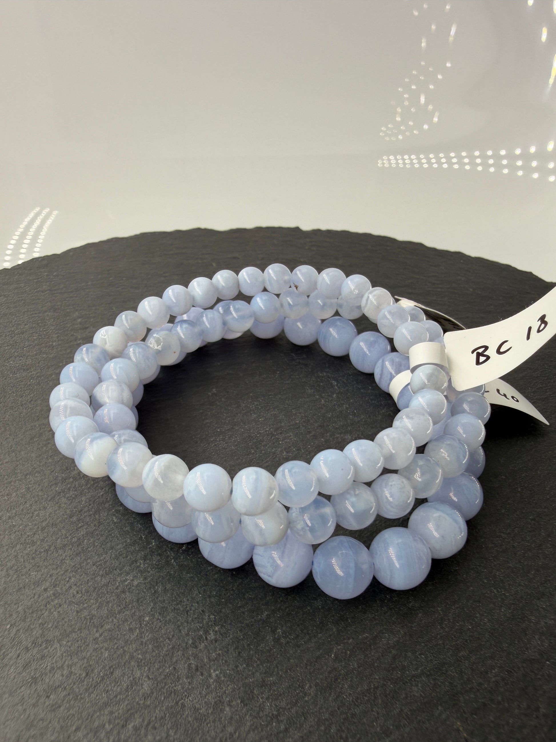 Ein zartblaues Kugelarmband aus poliertem Chalcedon, dessen gleichmäßige Perlen eine sanfte Lichtdurchlässigkeit und einen seidigen Glanz aufweisen.