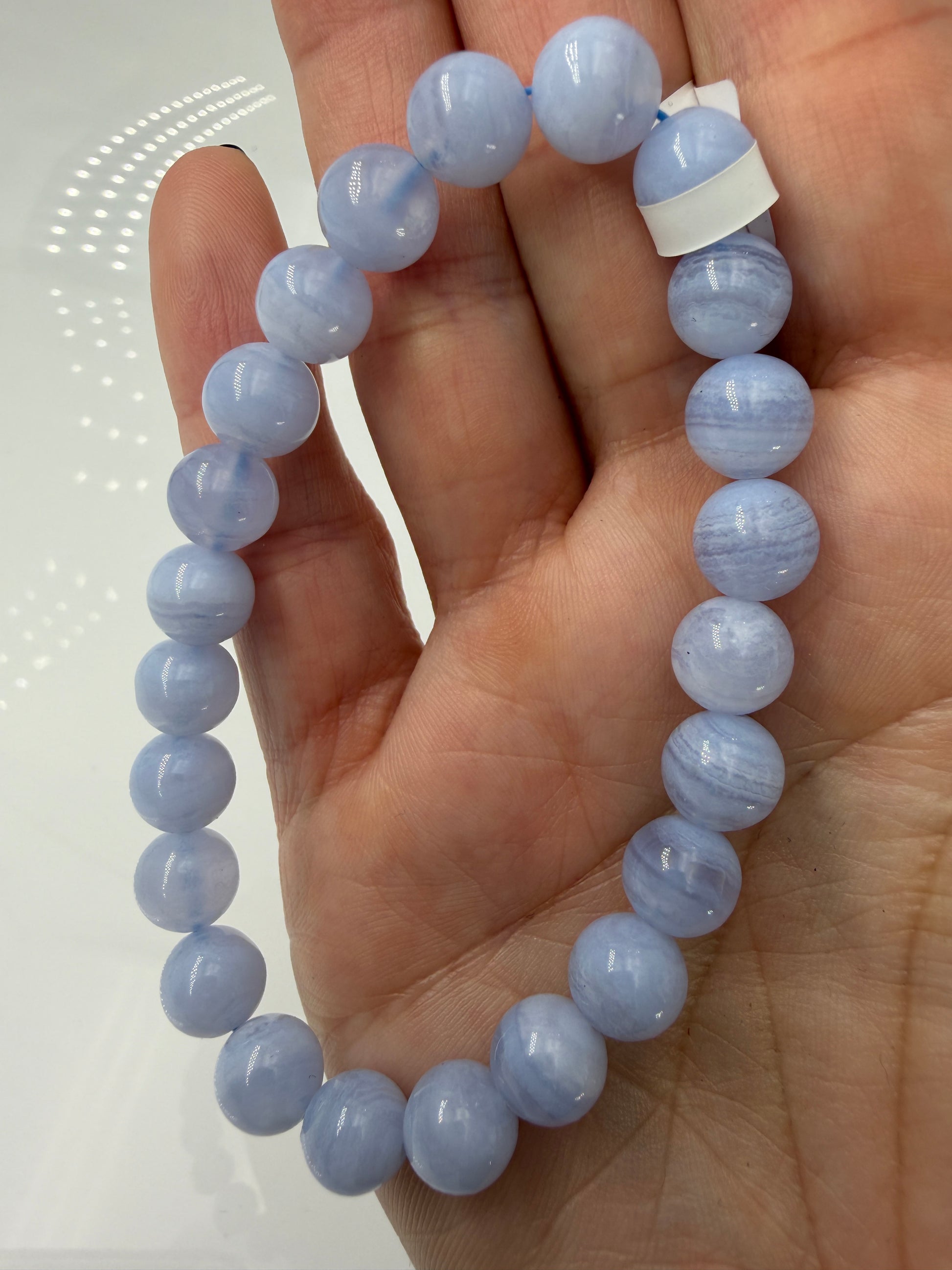 Ein zartblaues Kugelarmband aus poliertem Chalcedon, dessen gleichmäßige Perlen eine sanfte Lichtdurchlässigkeit und einen seidigen Glanz aufweisen.