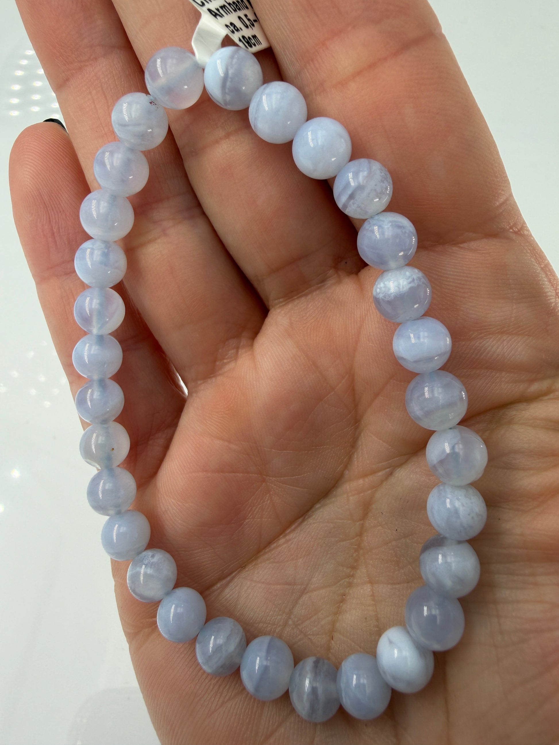 Ein zartblaues Kugelarmband aus poliertem Chalcedon, dessen gleichmäßige Perlen eine sanfte Lichtdurchlässigkeit und einen seidigen Glanz aufweisen.