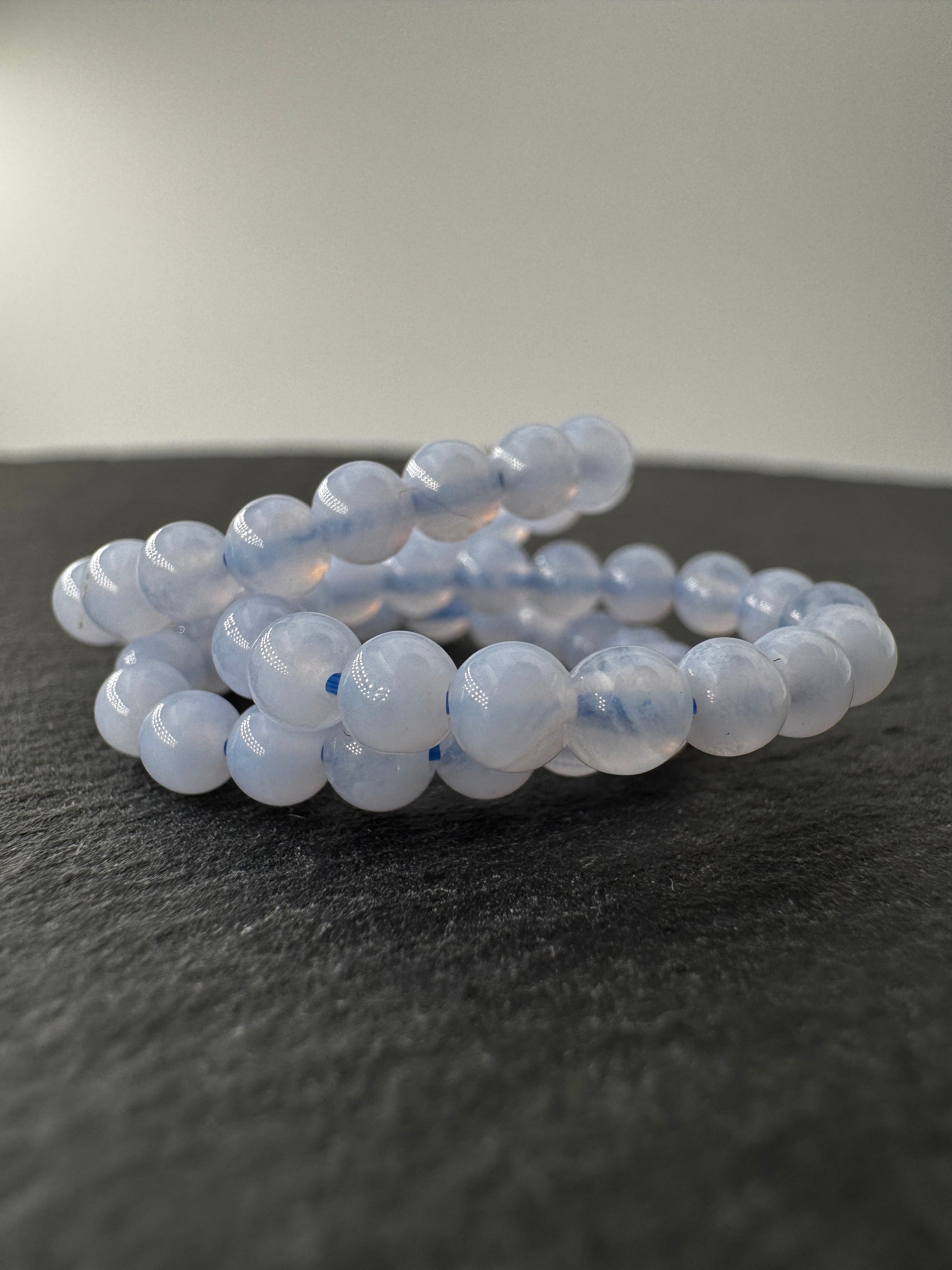Elastischer Ring aus blauem Chalcedon mit 3,8–4-mm-Kugeln – milchig-blaues Transluzenz-Spiel, Ringdurchmesser 6 cm.