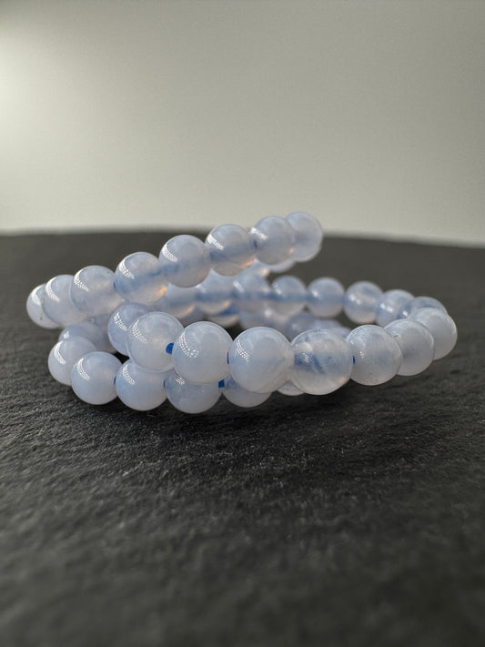 Elastischer Ring aus blauem Chalcedon mit 3,8–4-mm-Kugeln – milchig-blaues Transluzenz-Spiel, Ringdurchmesser 6 cm.