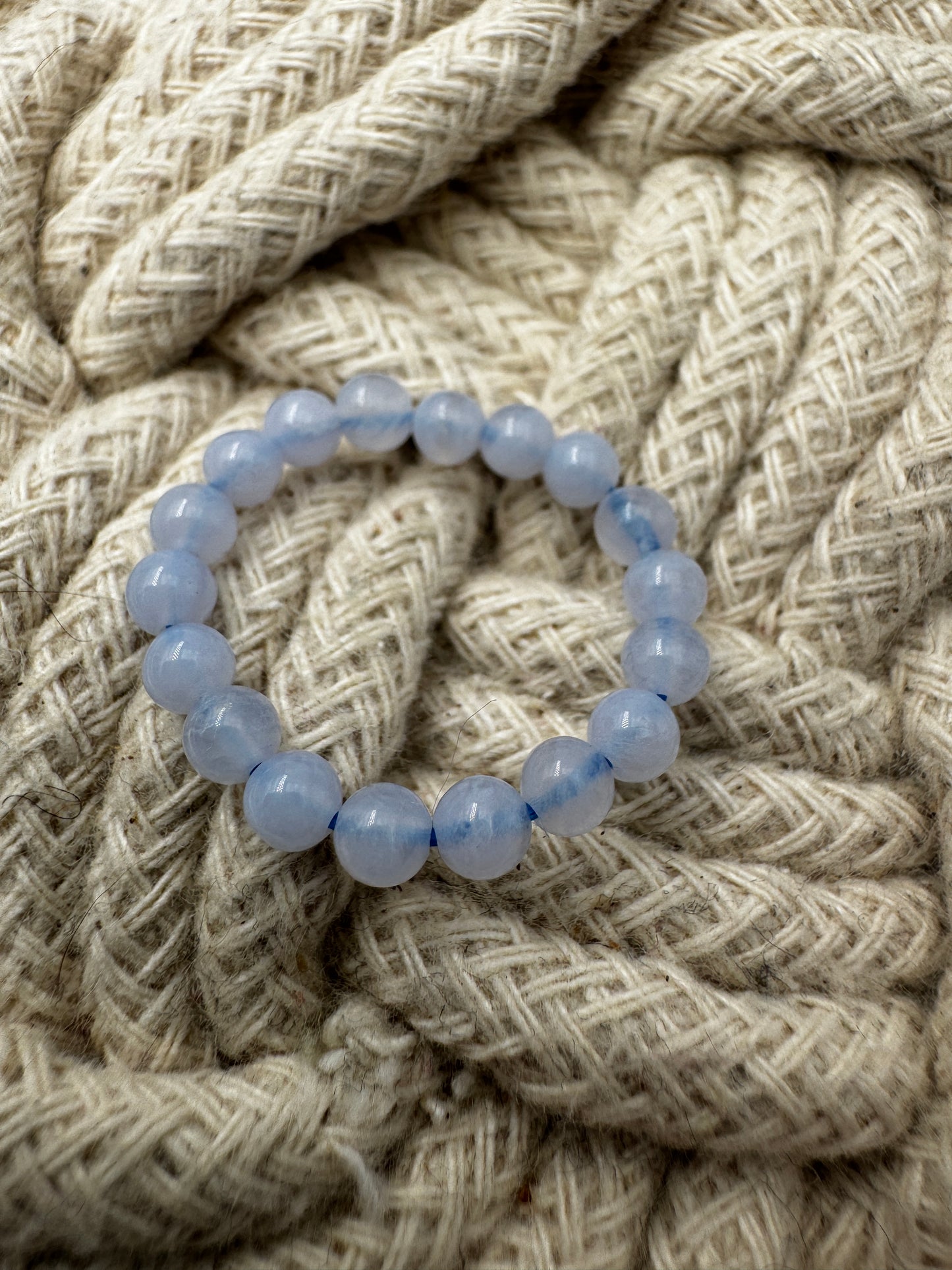 Elastischer Ring aus blauem Chalcedon mit 3,8–4-mm-Kugeln – milchig-blaues Transluzenz-Spiel, Ringdurchmesser 6 cm.