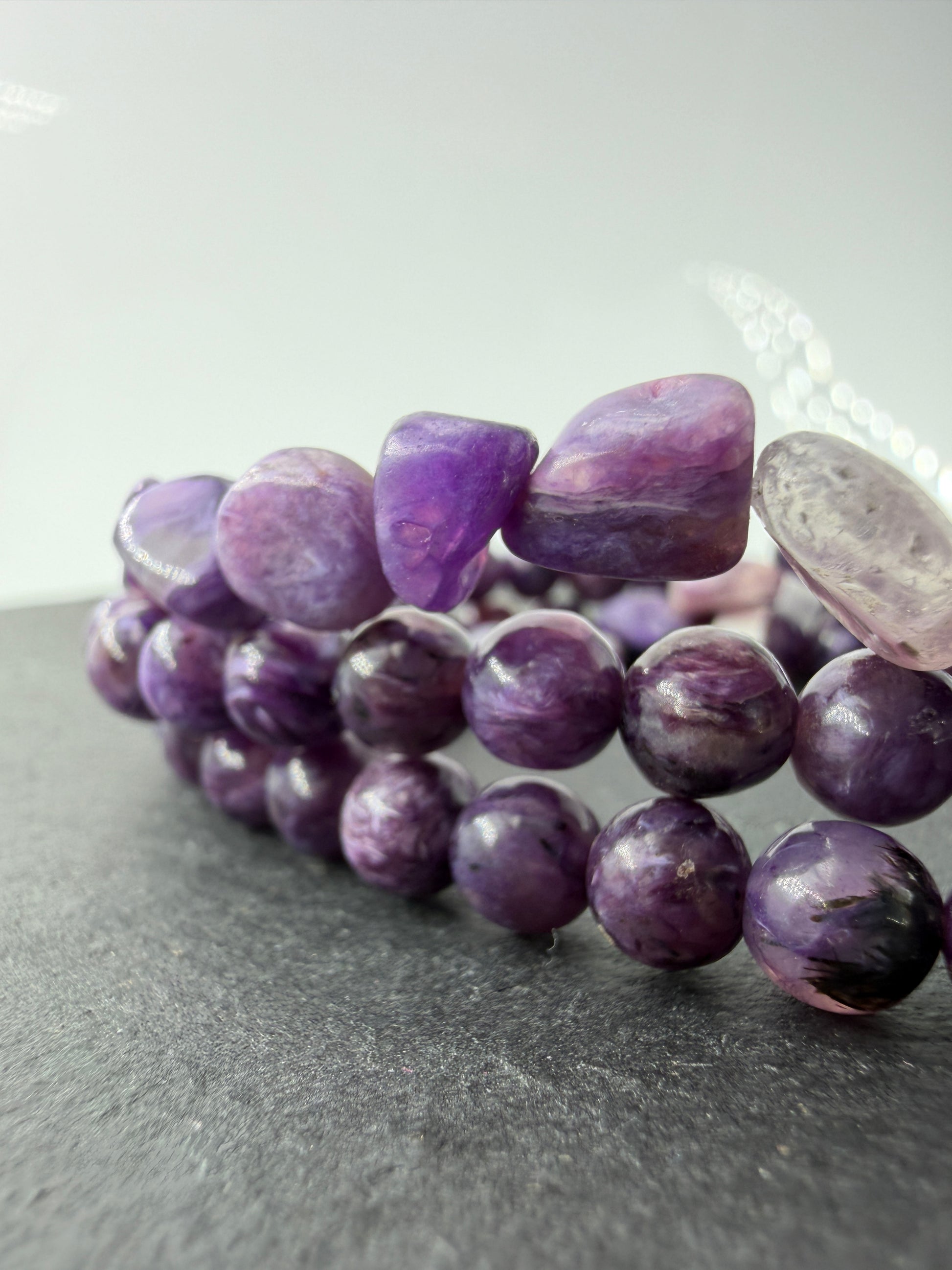 Ein hochwertiges Armband aus tiefvioletten Charoit-Perlen und Splittern, die eine faszinierende, wirbelförmige Maserung und einen sanften Perlmuttglanz aufweisen.