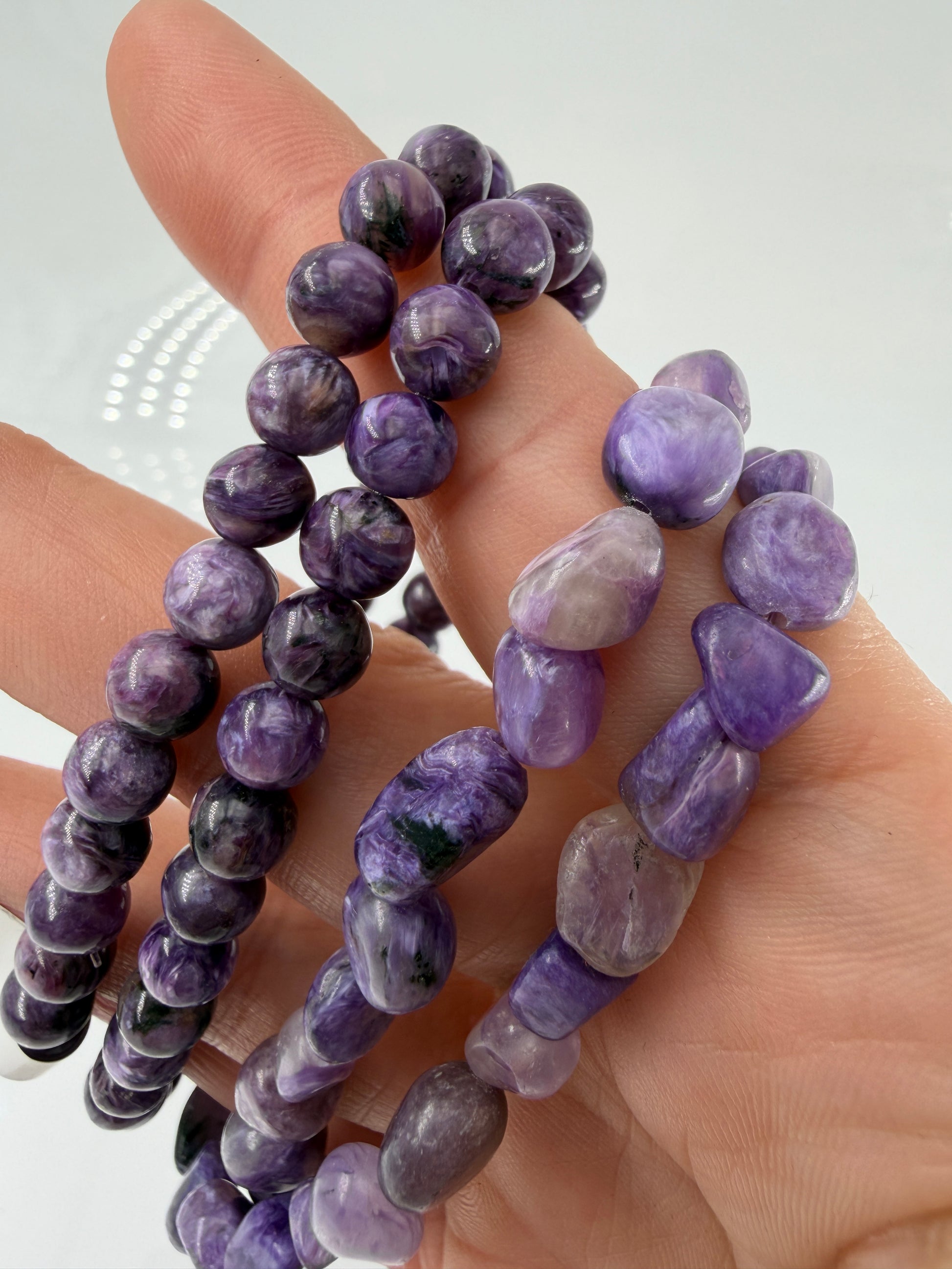 Ein hochwertiges Armband aus tiefvioletten Charoit-Perlen und Splittern, die eine faszinierende, wirbelförmige Maserung und einen sanften Perlmuttglanz aufweisen.