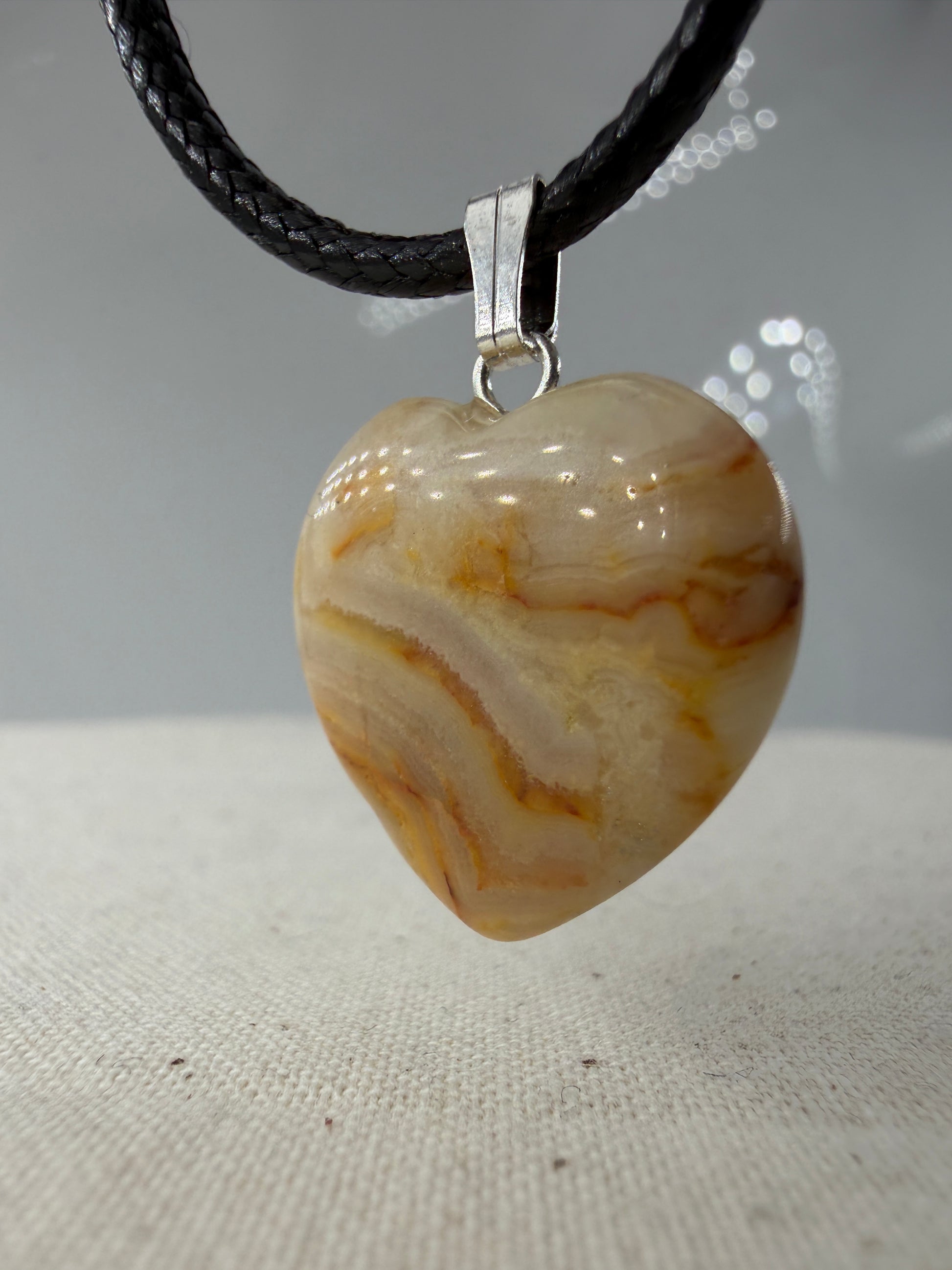 Herzförmiger Crazy Lace Achat Cabochon-Anhänger CH2 mit wellenförmiger Bänderung.