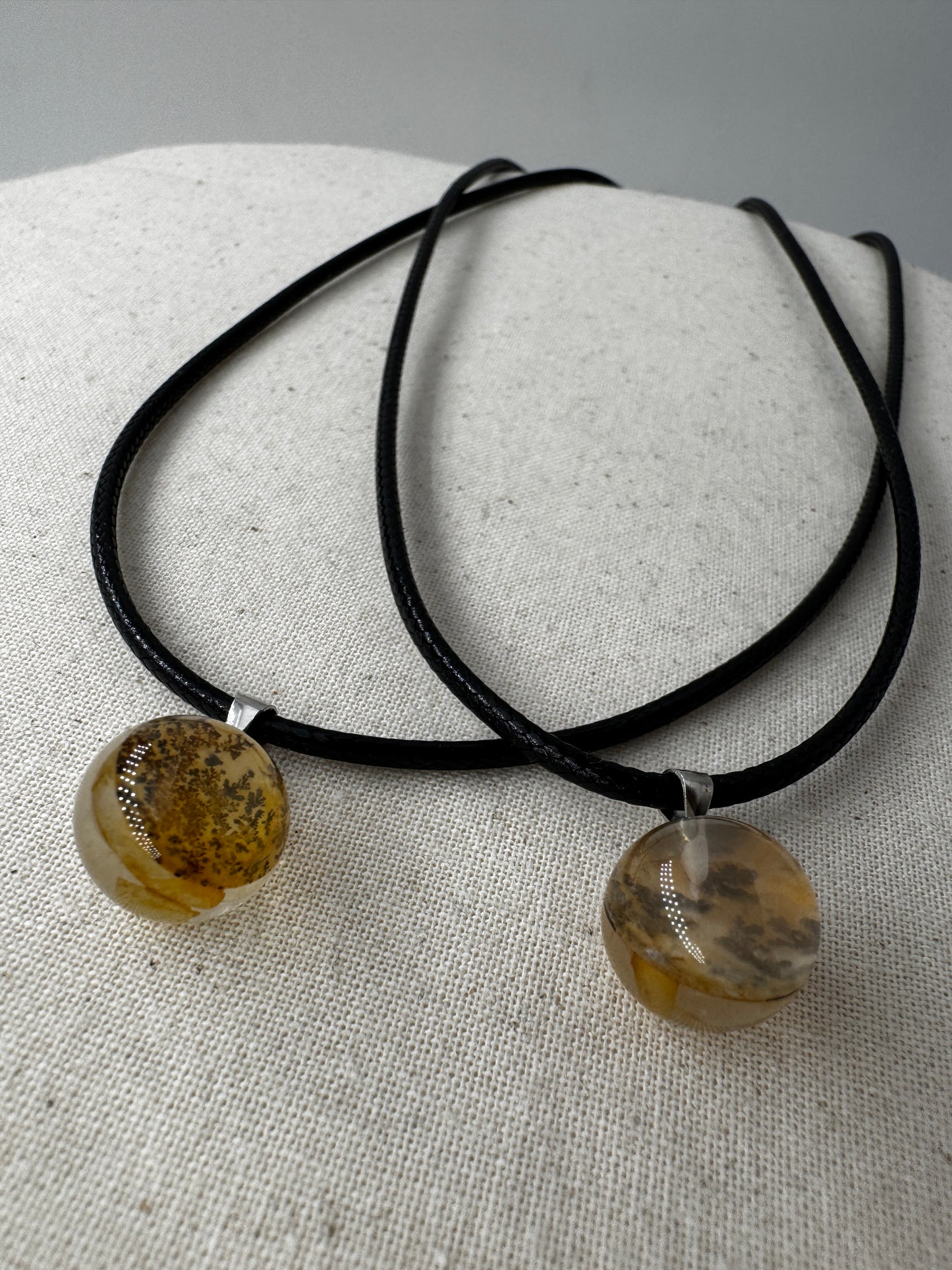 Dendritenquarz-Kugelanhänger mit Mangan-Dendriten und goldenen Eisenoxid-Einschlüssen.