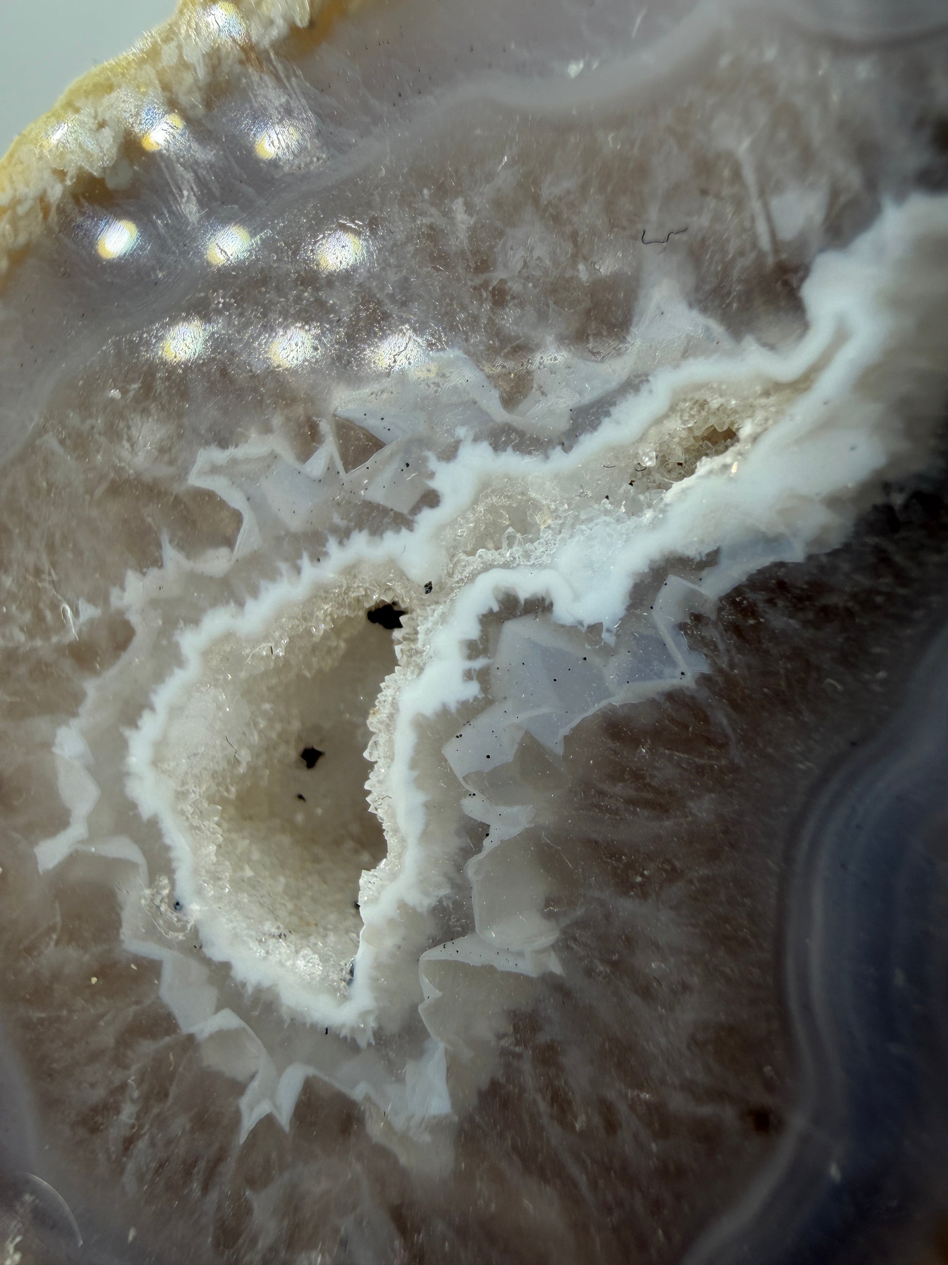 Detailansicht der kristallinen Quarzdruse im Inneren einer Achatgeode, zeigt terminierte Bergkristall-Spitzen.