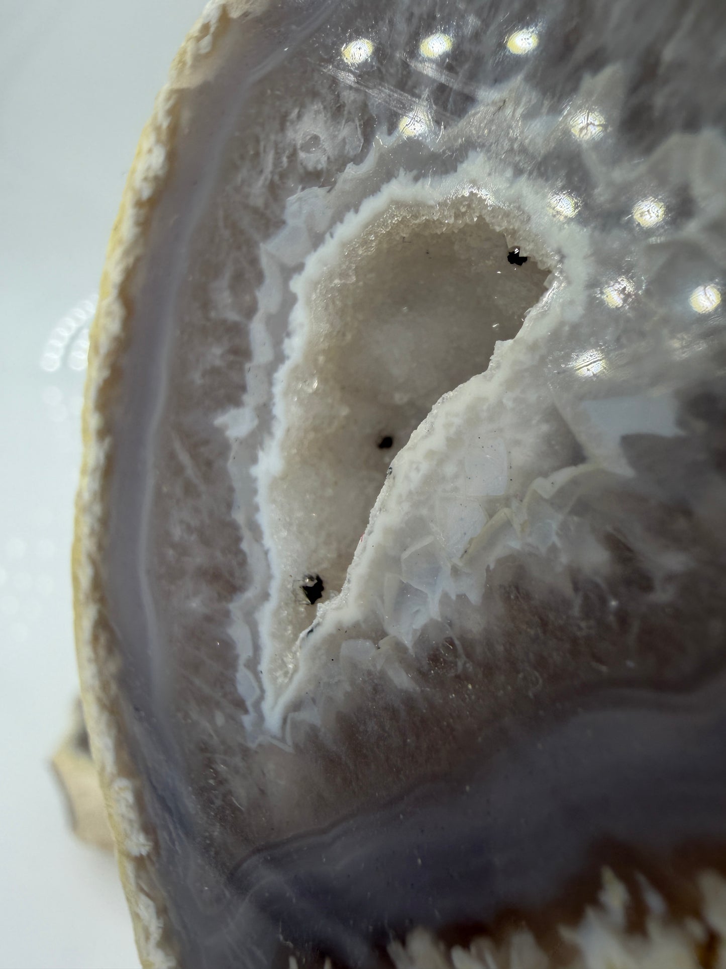 Detailansicht der kristallinen Quarzdruse im Inneren einer Achatgeode, zeigt terminierte Bergkristall-Spitzen.