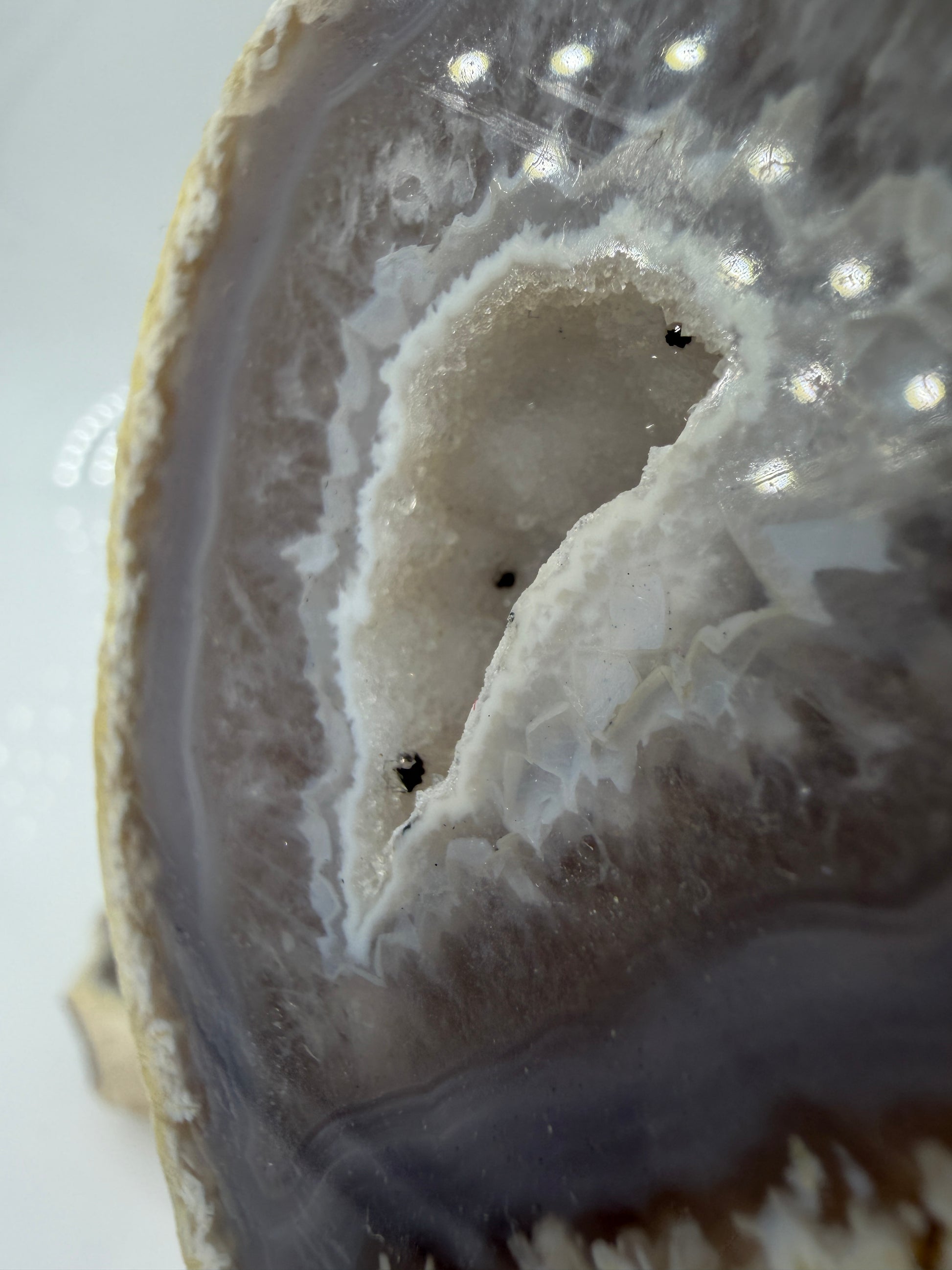 Detailansicht der kristallinen Quarzdruse im Inneren einer Achatgeode, zeigt terminierte Bergkristall-Spitzen.