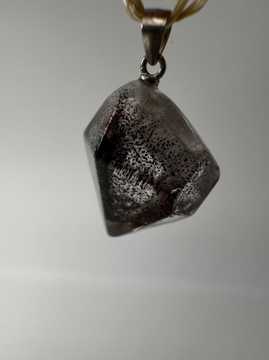 Nahaufnahme eines Eisenkiesel Anhängers aus Quarz mit Eiseneinschlüssen, silber gestiftet.