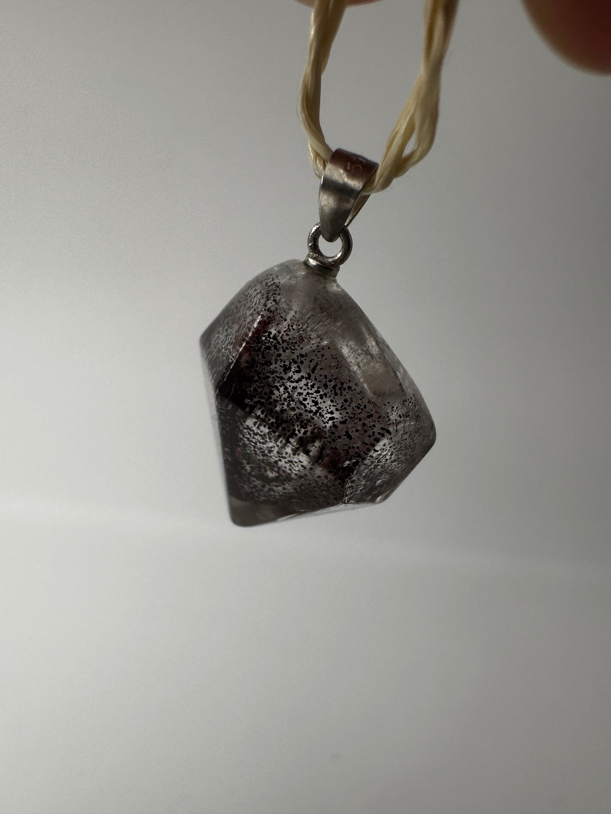 Nahaufnahme eines Eisenkiesel Anhängers aus Quarz mit Eiseneinschlüssen, silber gestiftet.