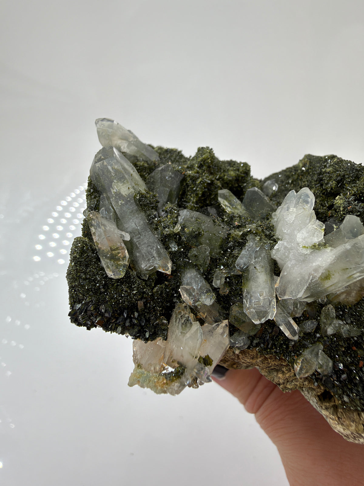 Epidotstufe ET108 mit olivgrüner, fein kristalliner Oberfläche und hellen, teils durchscheinenden Quarzspitzen