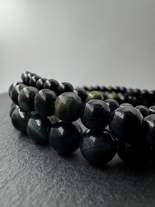 Elegantes Kugelarmband aus dunkelblau-schwarzem Falkenauge mit charakteristischem faserigem Lichtschein.