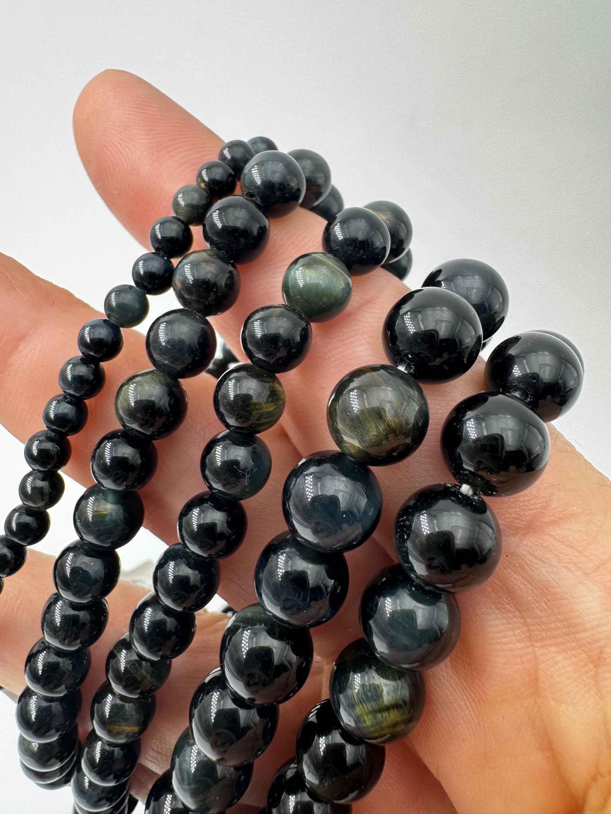 Elegantes Kugelarmband aus dunkelblau-schwarzem Falkenauge mit charakteristischem faserigem Lichtschein.