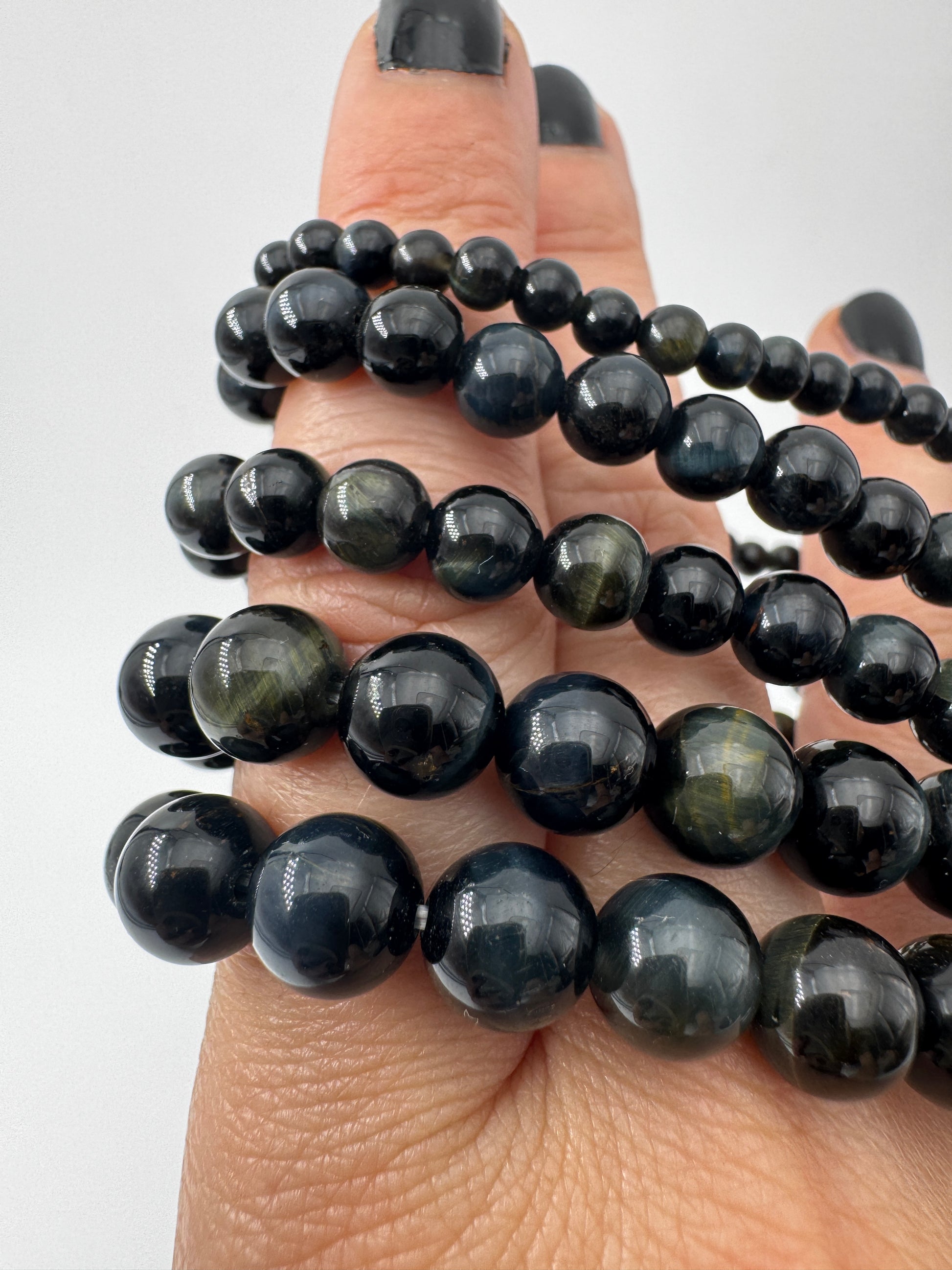 Elegantes Kugelarmband aus dunkelblau-schwarzem Falkenauge mit charakteristischem faserigem Lichtschein.
