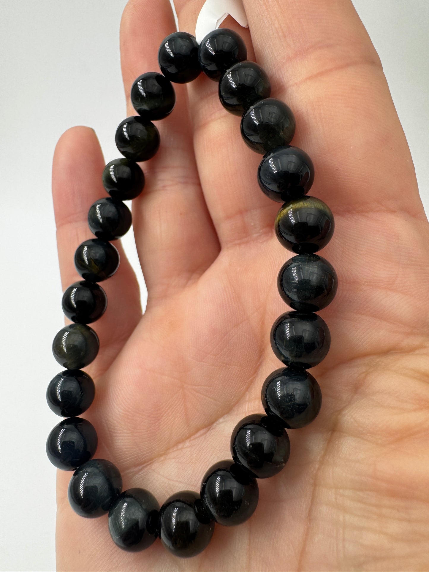 Elegantes Kugelarmband aus dunkelblau-schwarzem Falkenauge mit charakteristischem faserigem Lichtschein.