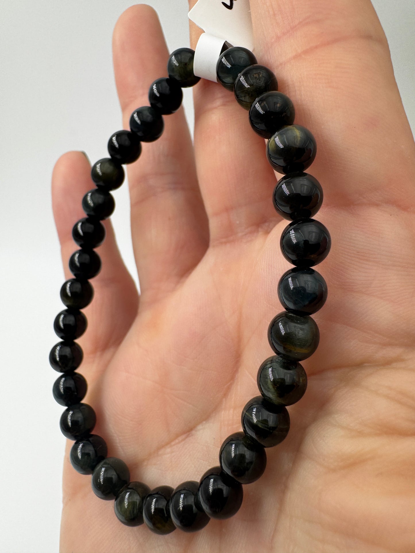 Elegantes Kugelarmband aus dunkelblau-schwarzem Falkenauge mit charakteristischem faserigem Lichtschein.