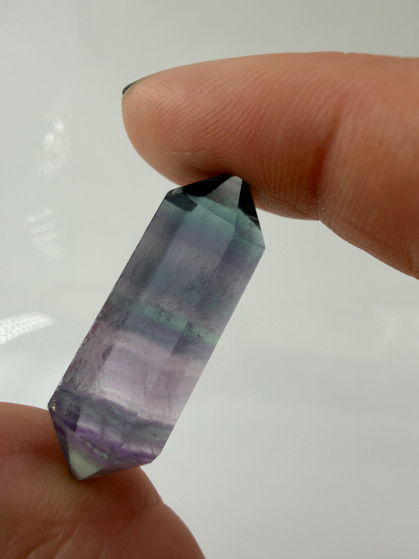 Beidseitig zugespitzter Fluorit-Doppelender mit sichtbarer Farbzonierung und polierten Flächen.