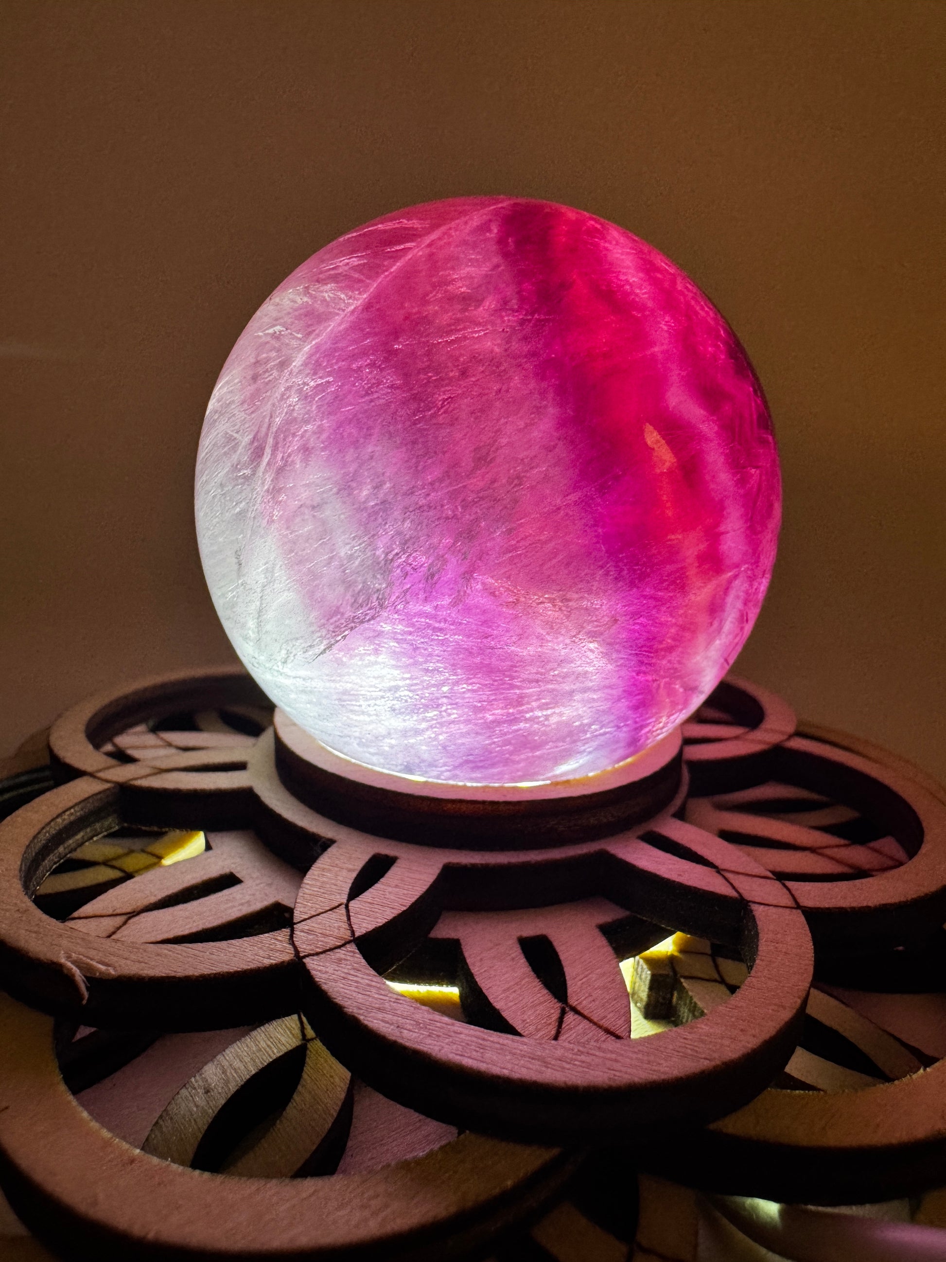 Fluorit-Kugel mit natürlichem Rosa-Grün-Farbverlauf und feiner Zonierung auf einem Leuchtsockel.