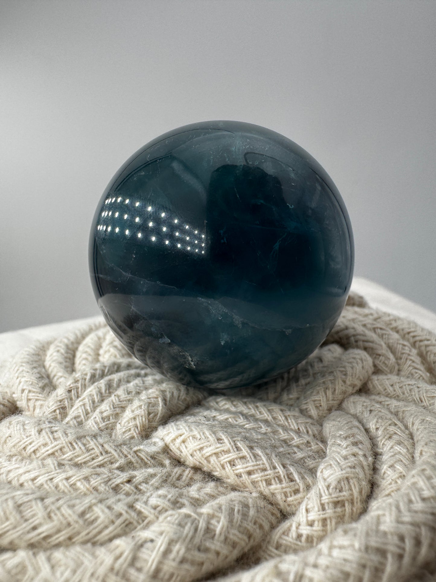 Eine perfekt polierte Kugel aus blauem Fluorit mit faszinierenden Farbzonen.
