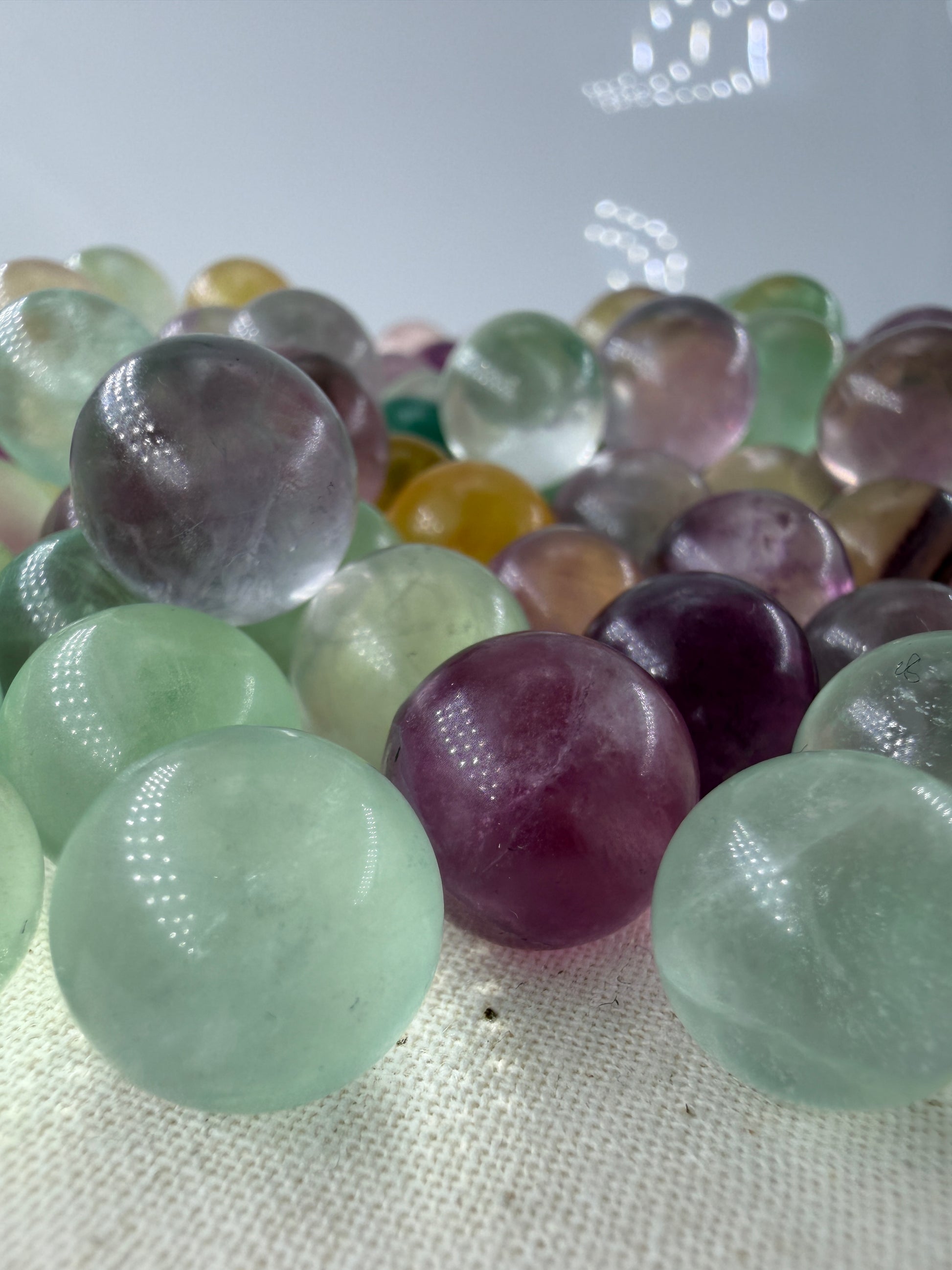 Fluorit Minikugel mit zonarer Farbgebung in Violett und Grün und Gelb.