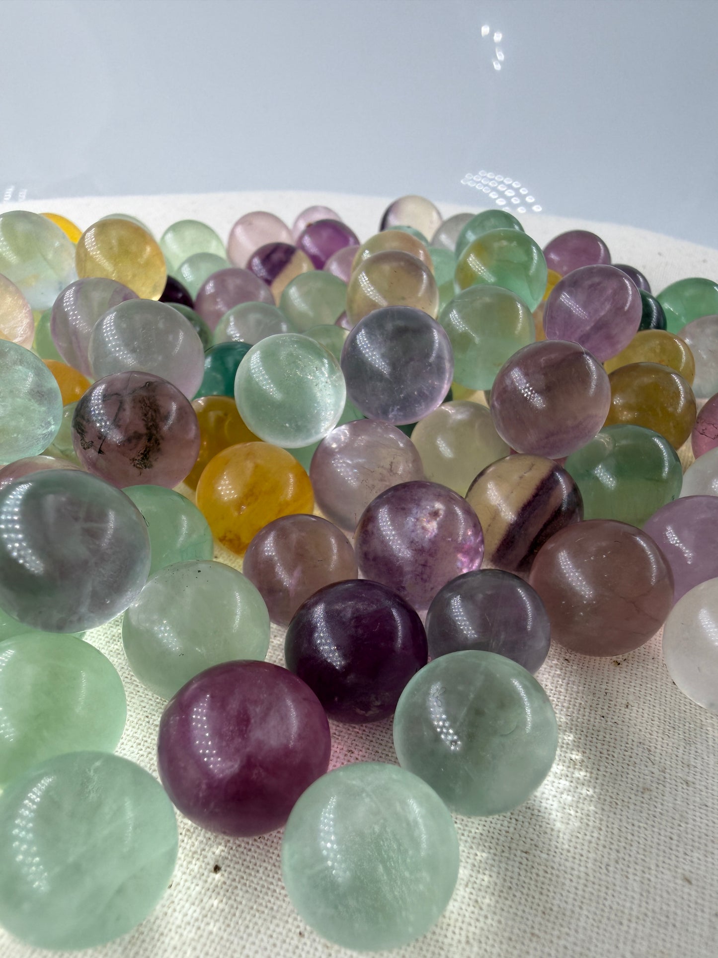 Fluorit Minikugel mit zonarer Farbgebung in Violett und Grün und Gelb.
