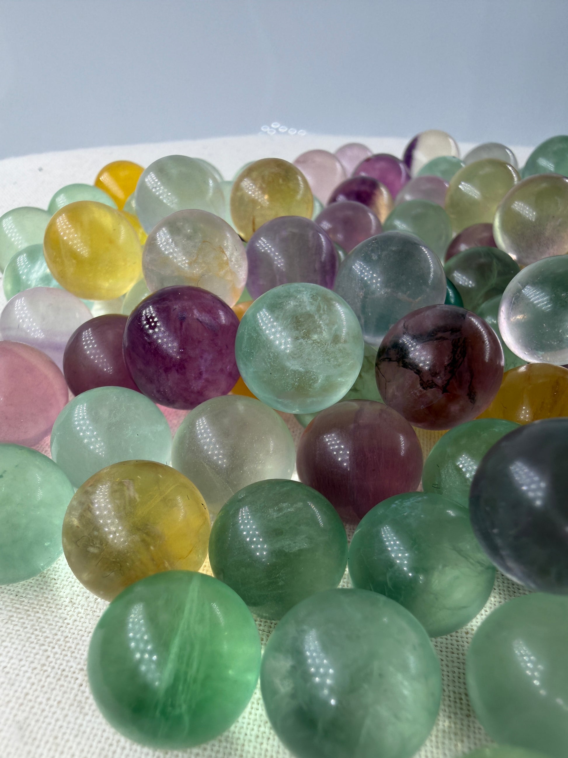 Fluorit Minikugel mit zonarer Farbgebung in Violett und Grün und Gelb.