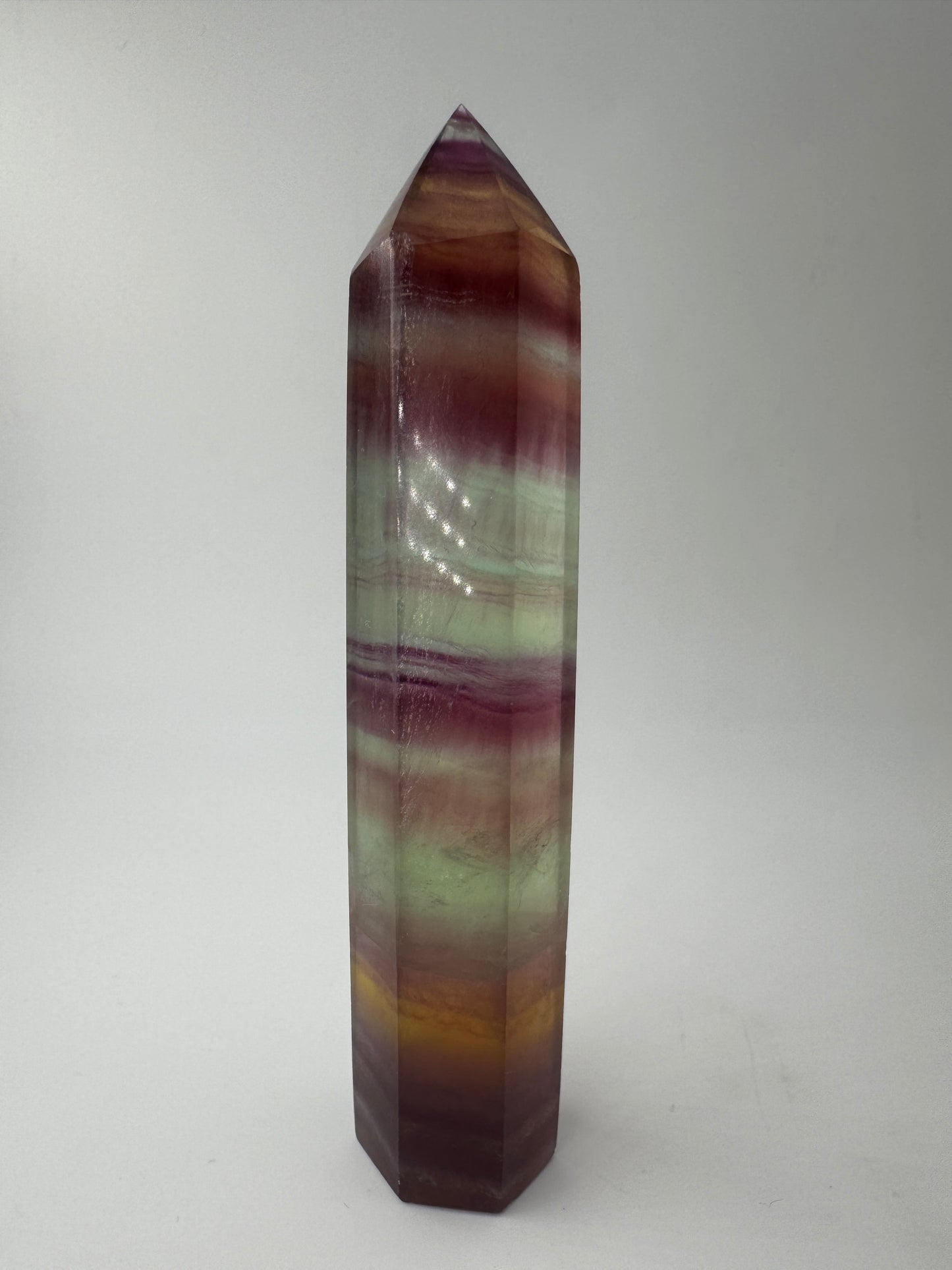 Geschliffene Fluorit-Spitze in Turmform mit natürlichem Farbspiel, Höhe 12,4 cm.