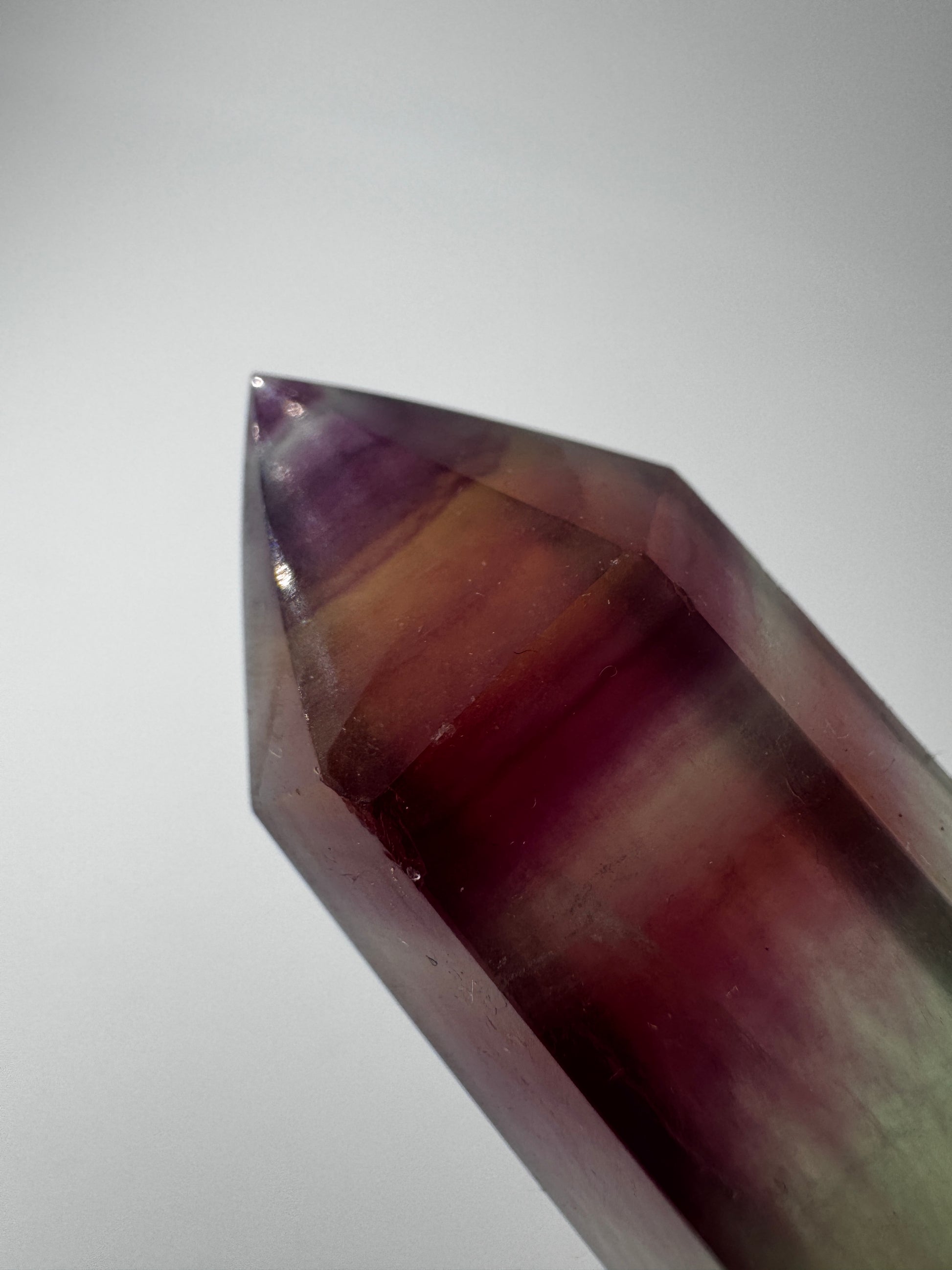 Geschliffene Fluorit-Spitze in Turmform mit natürlichem Farbspiel, Höhe 12,4 cm.