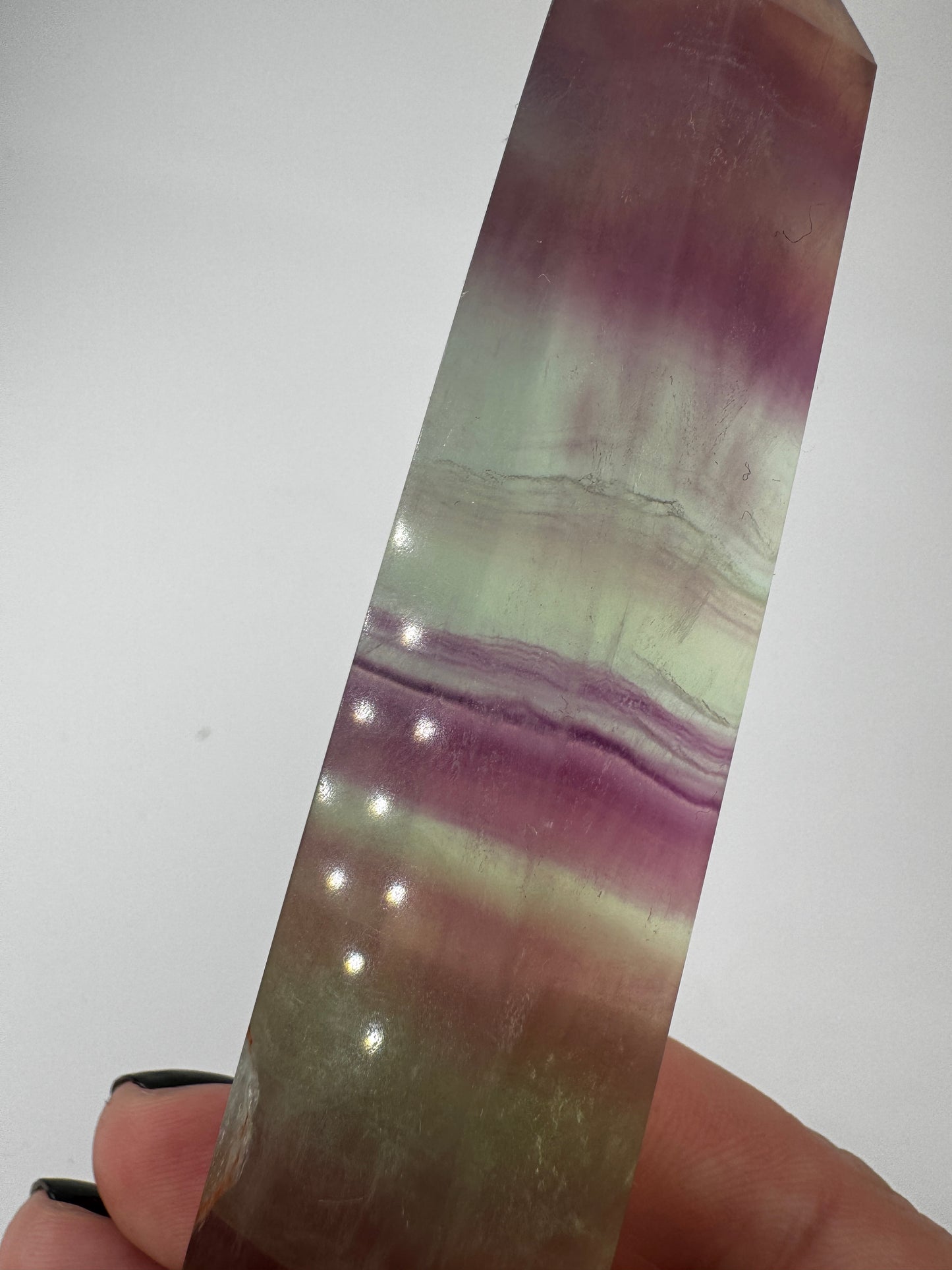Geschliffene Fluorit-Spitze in Turmform mit natürlichem Farbspiel, Höhe 12,4 cm.