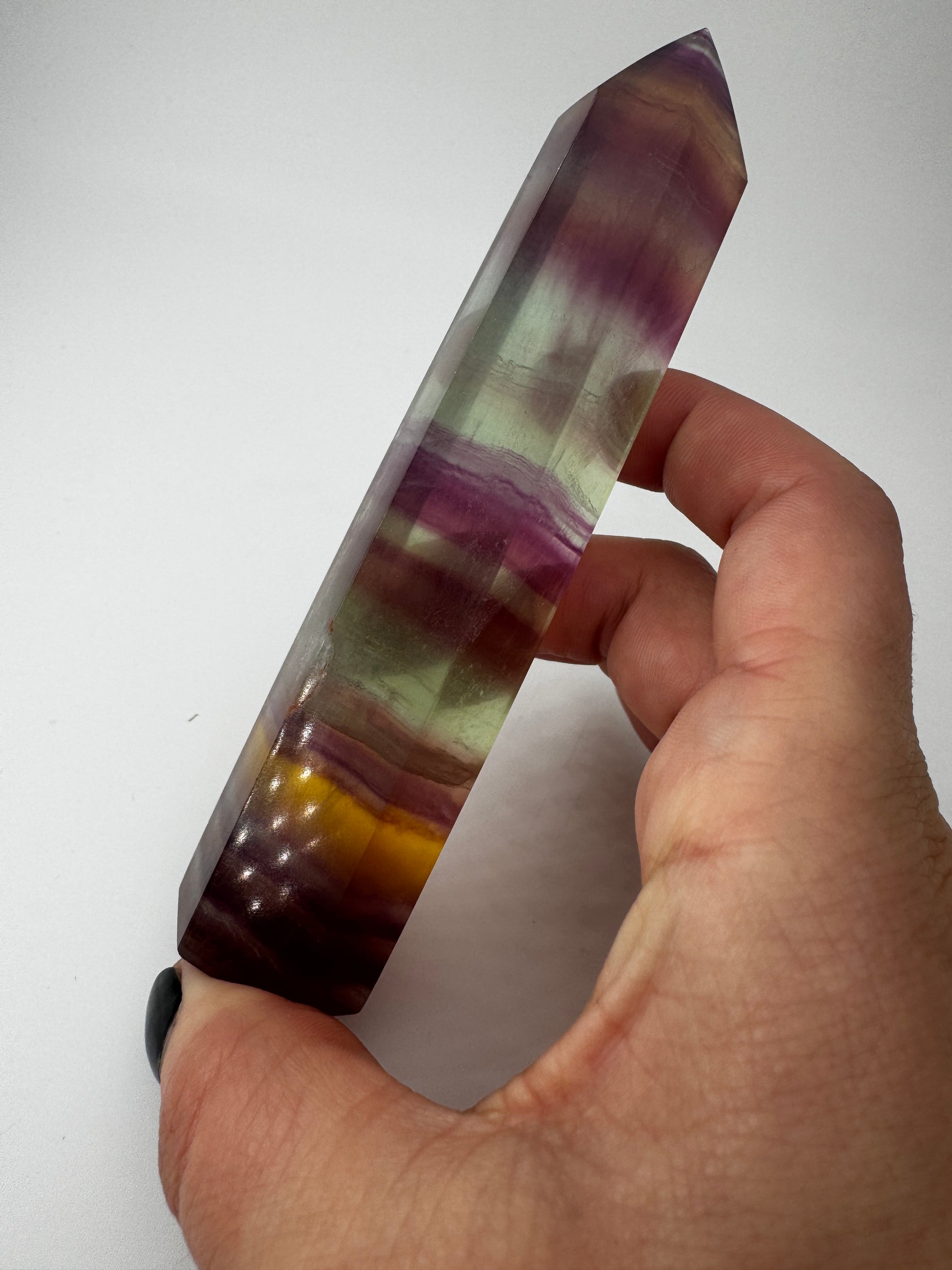 Geschliffene Fluorit-Spitze in Turmform mit natürlichem Farbspiel, Höhe 12,4 cm.