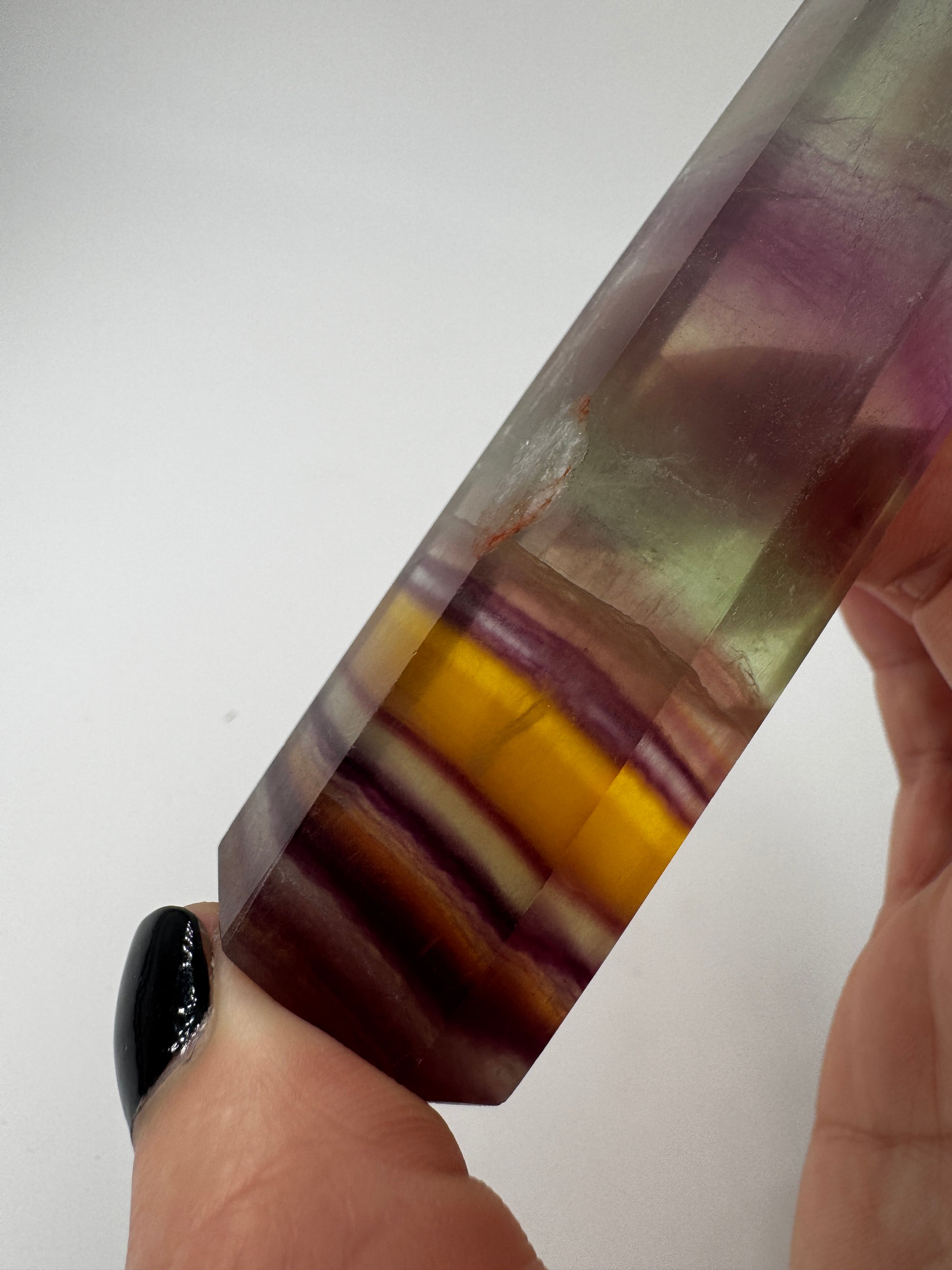 Geschliffene Fluorit-Spitze in Turmform mit natürlichem Farbspiel, Höhe 12,4 cm.