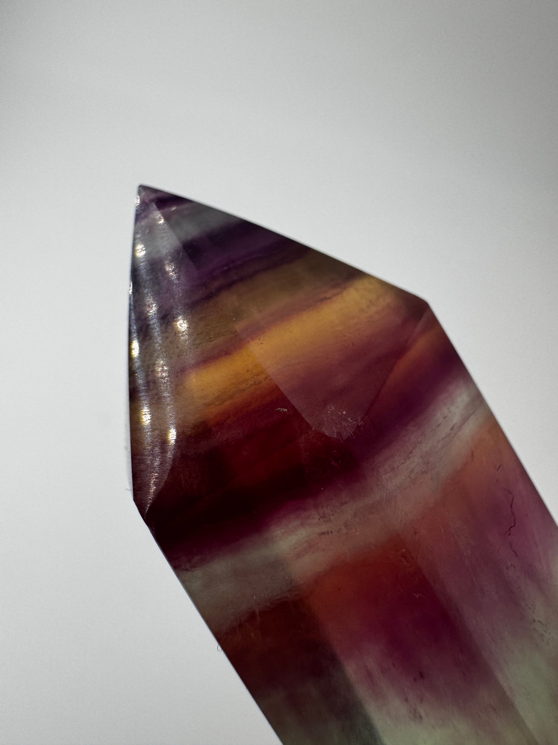 Geschliffene Fluorit-Spitze in Turmform mit natürlichem Farbspiel, Höhe 12,4 cm.