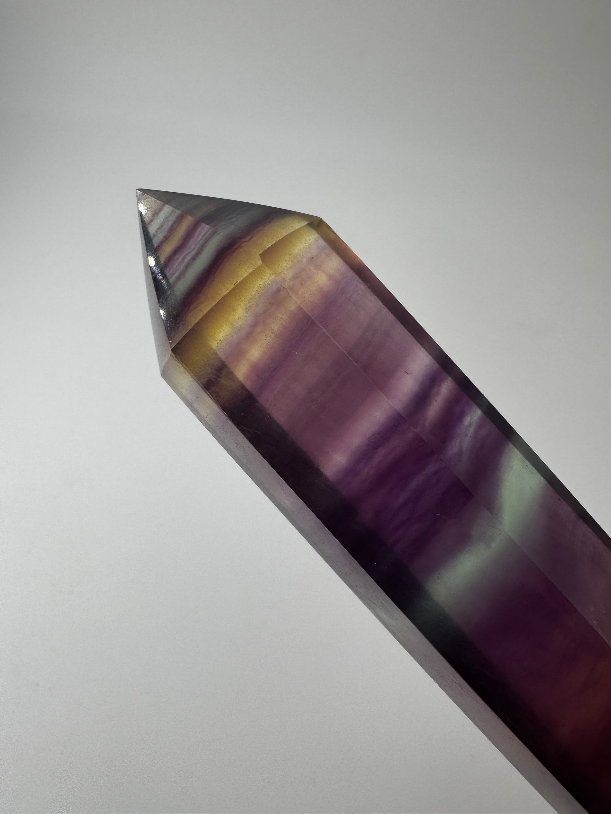 Geschliffene Fluorit-Spitze in Turmform mit natürlichem Farbspiel, Höhe 14,5 cm.