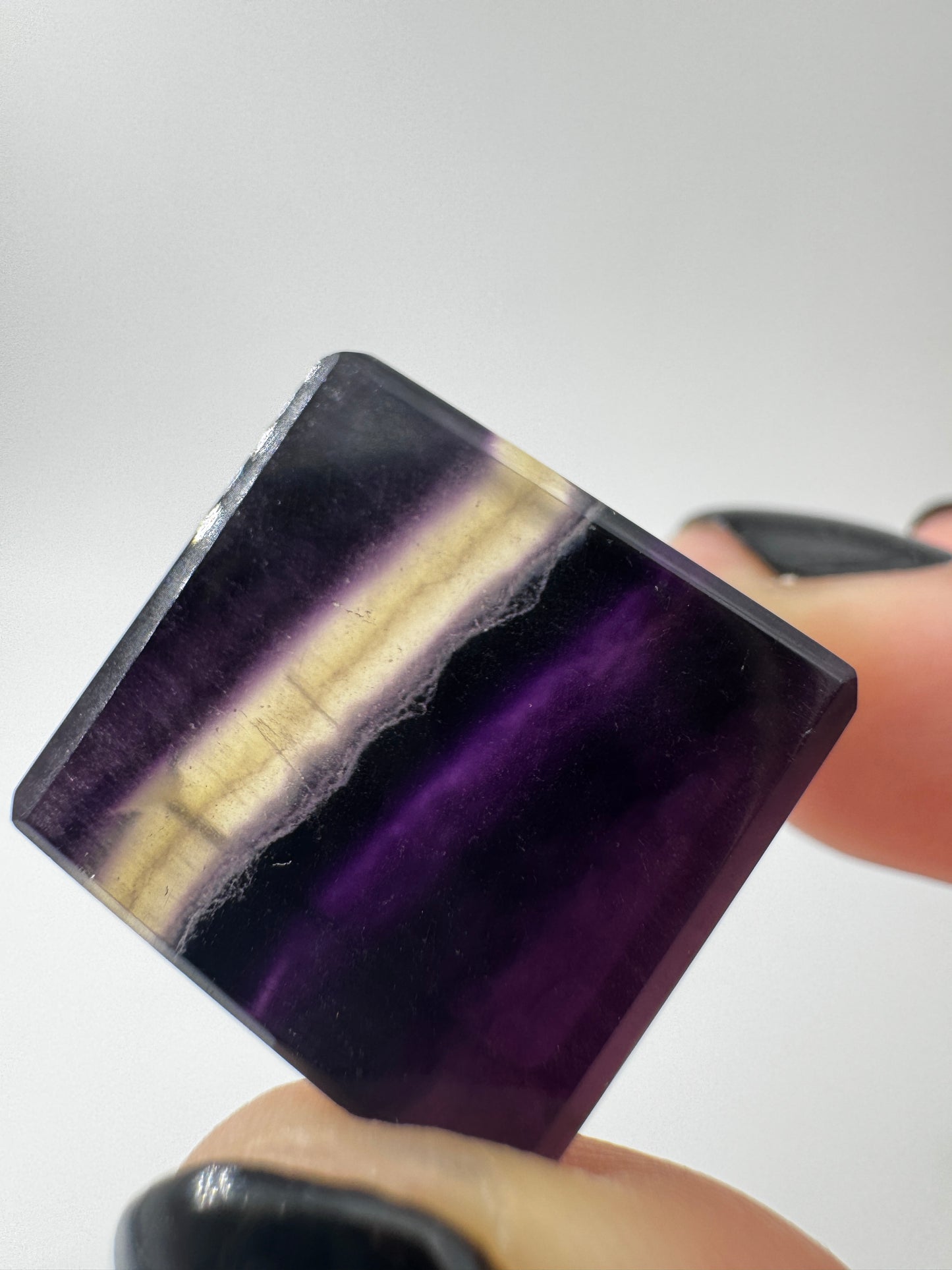 Ein transparenter Fluorit-Würfel mit deutlich sichtbaren violetten Farbbändern.