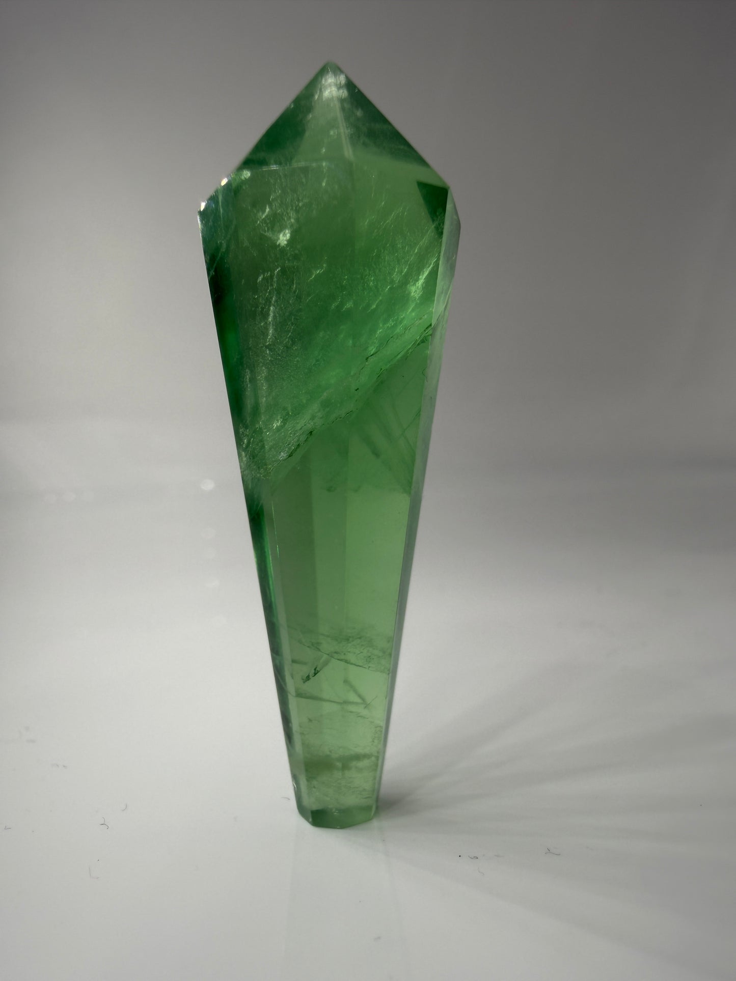 Natürliches Fluorit-Zepter mit charakteristischem Kristallkopf, deutlicher Zonierung und gläsernem Glanz.