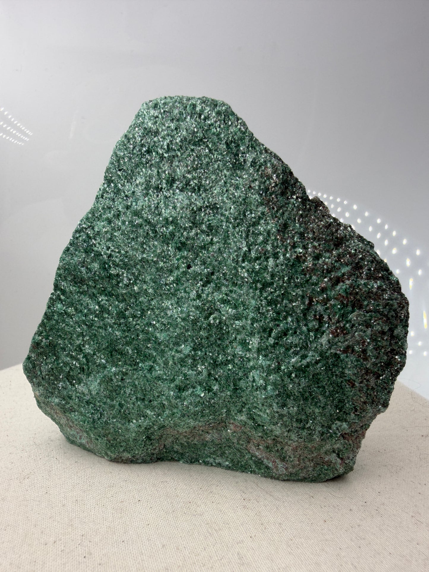 Smaragdgrüner Fuchsit-Rohstein aus Brasilien mit intensiv glitzernder, blättriger Glimmeroberfläche.