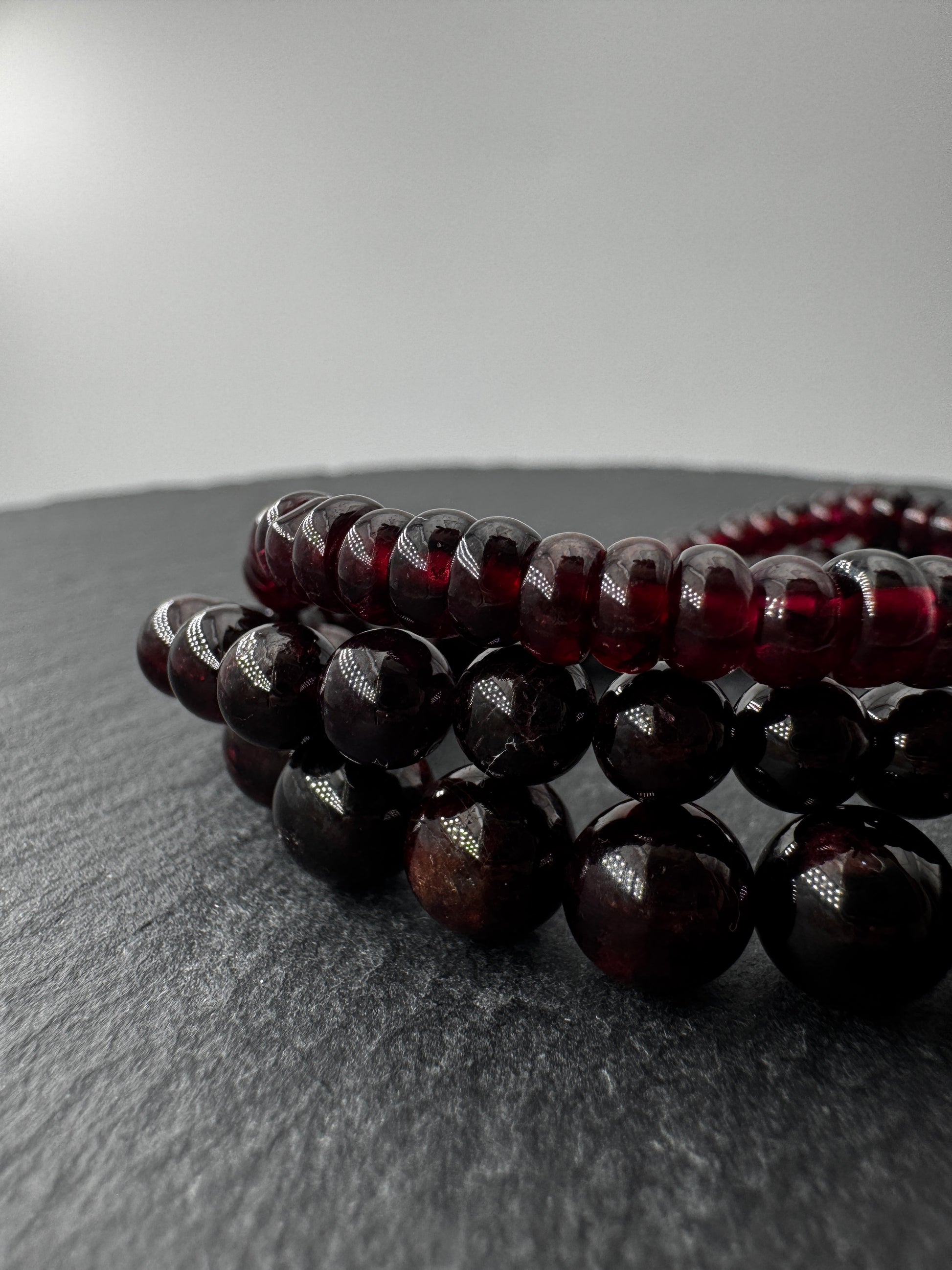 Ein filigranes Armband aus glänzenden, dunkelroten Granat-Kugeln.