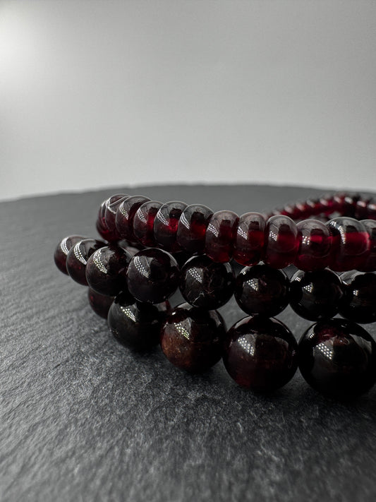 Ein filigranes Armband aus glänzenden, dunkelroten Granat-Kugeln.