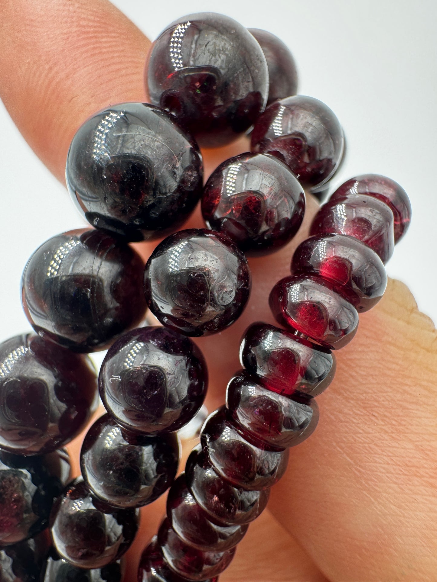 Ein filigranes Armband aus glänzenden, dunkelroten Granat-Kugeln.