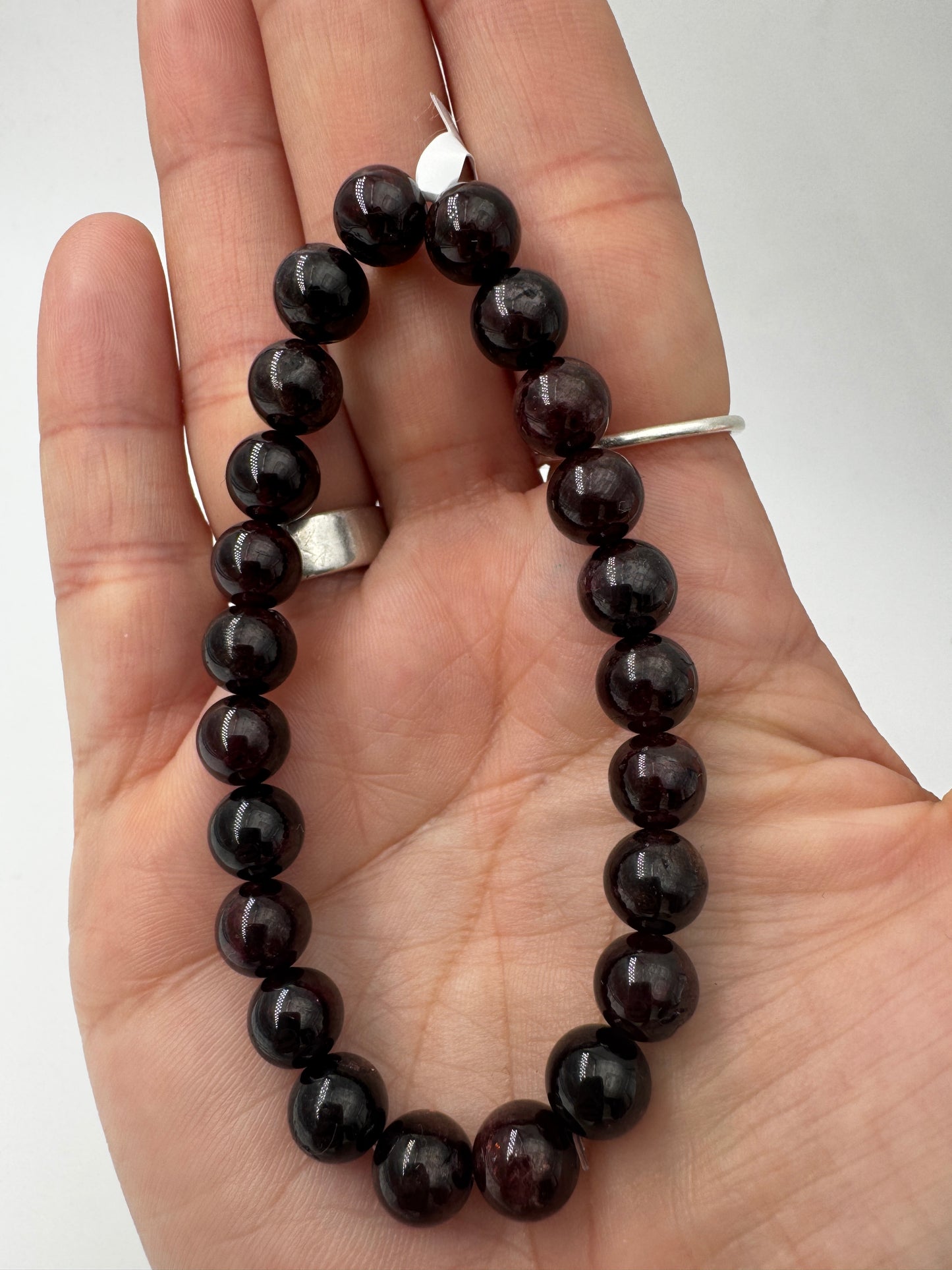 Ein filigranes Armband aus glänzenden, dunkelroten Granat-Kugeln.