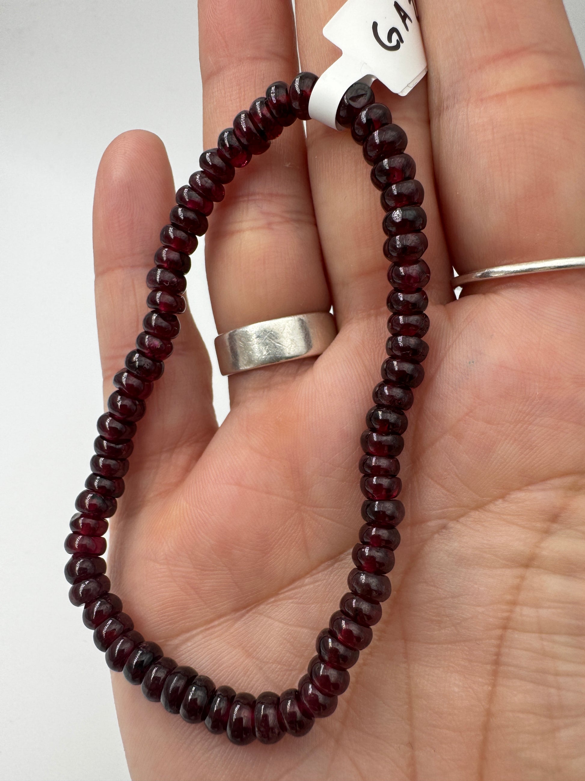 Ein filigranes Armband aus glänzenden, dunkelroten Granat-Kugeln.