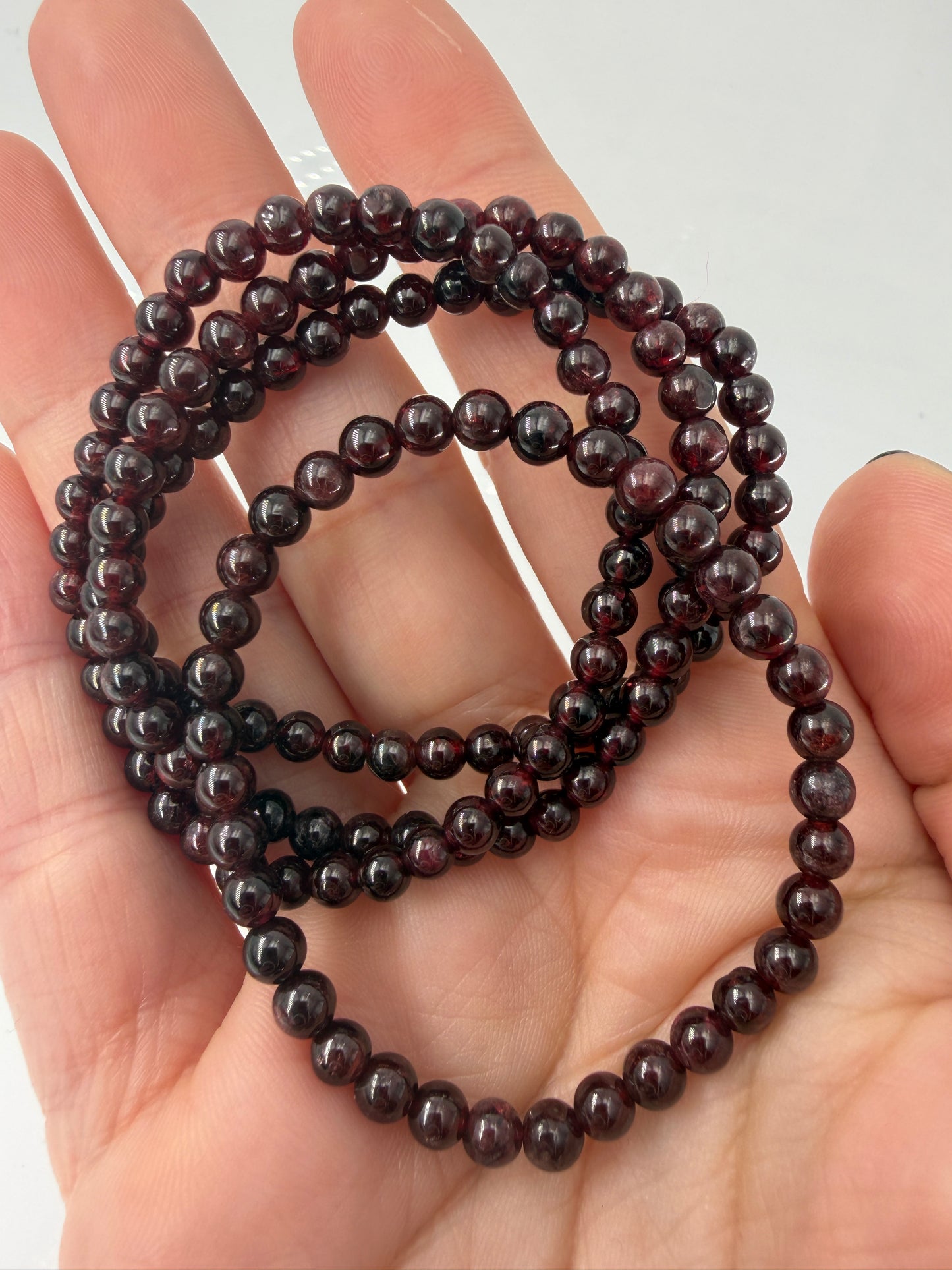 Dunkelrotes Kugelarmband aus poliertem Granat auf einem elastischen Band für Kinder.