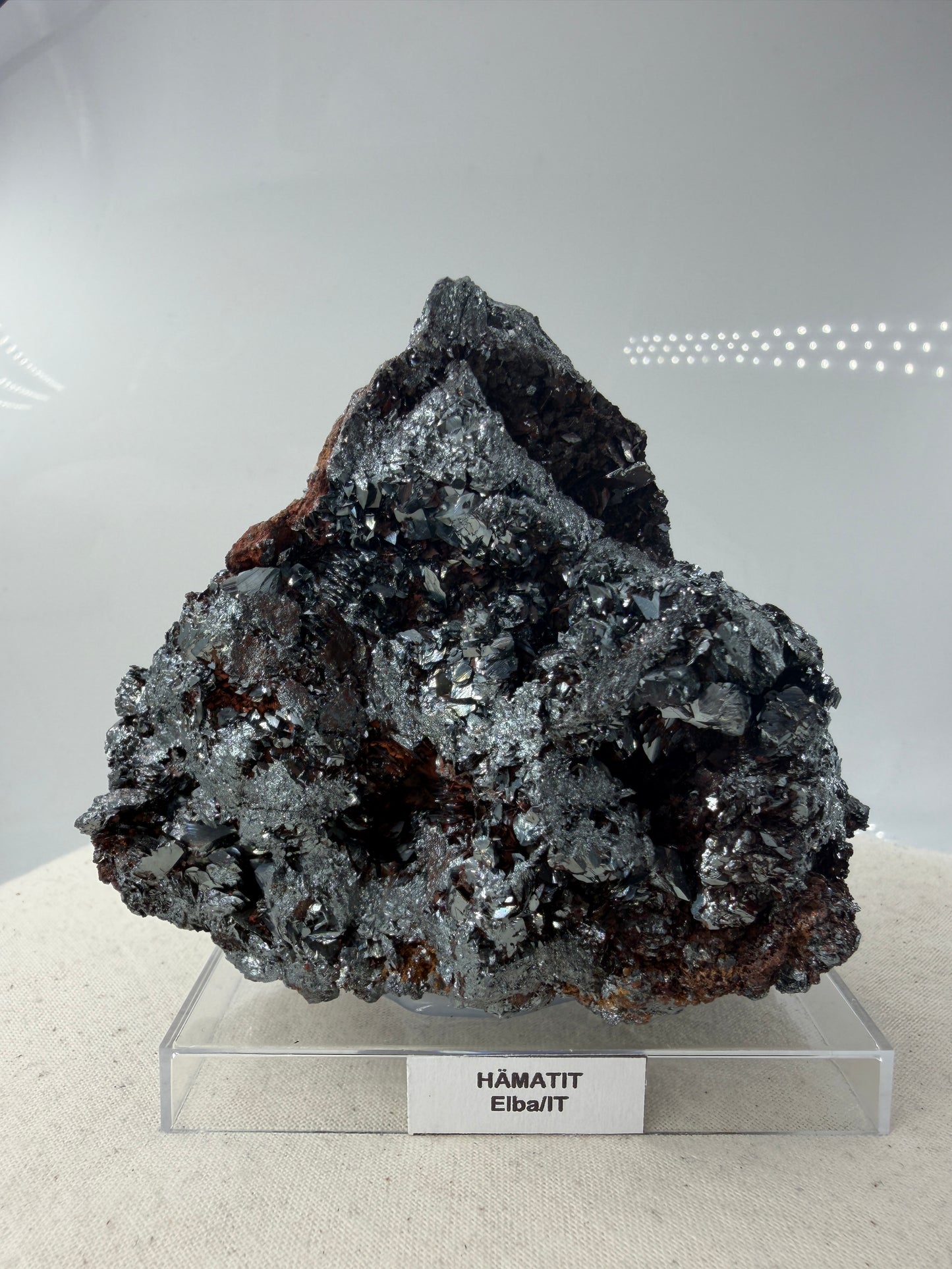 Hämatit-Specimen aus Elba, Italien, mit hochglänzenden, metallischen Mineralkristallen und charakteristischer linsenförmiger Struktur.